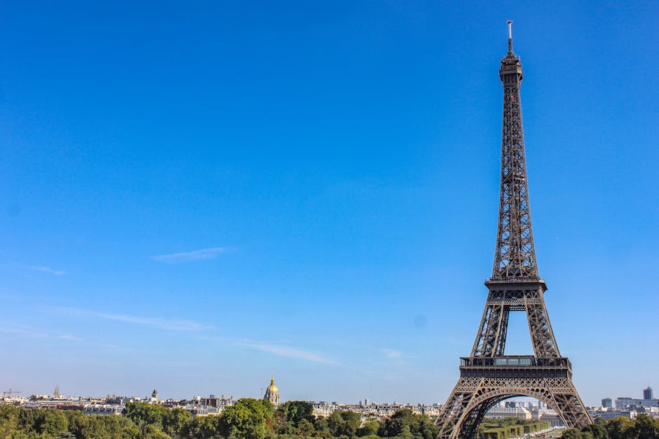 Stunning daytime view of the Eiffel Tower against a clear blue sky in Paris, France.
