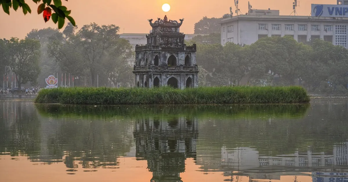Hanoi, Vietnam — the Turtle Tower on its island in Hoan Kiem Lake, mirrored in still water at sunrise