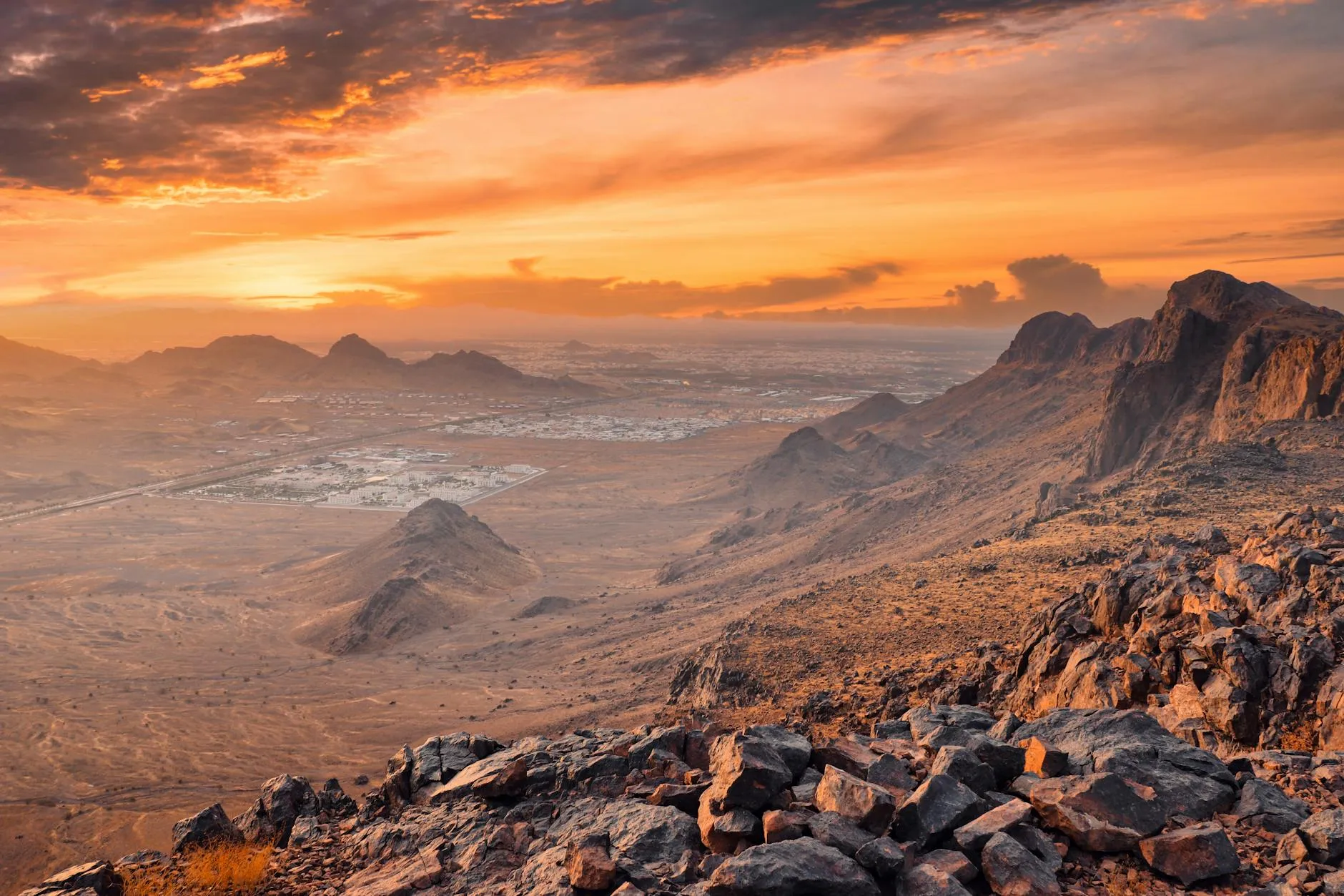 Abha, Saudi Arabia — Panoramic view of rocky desert landscape in Medina, Saudi Arabia at sunset, showcasing vibrant sky and mountains.