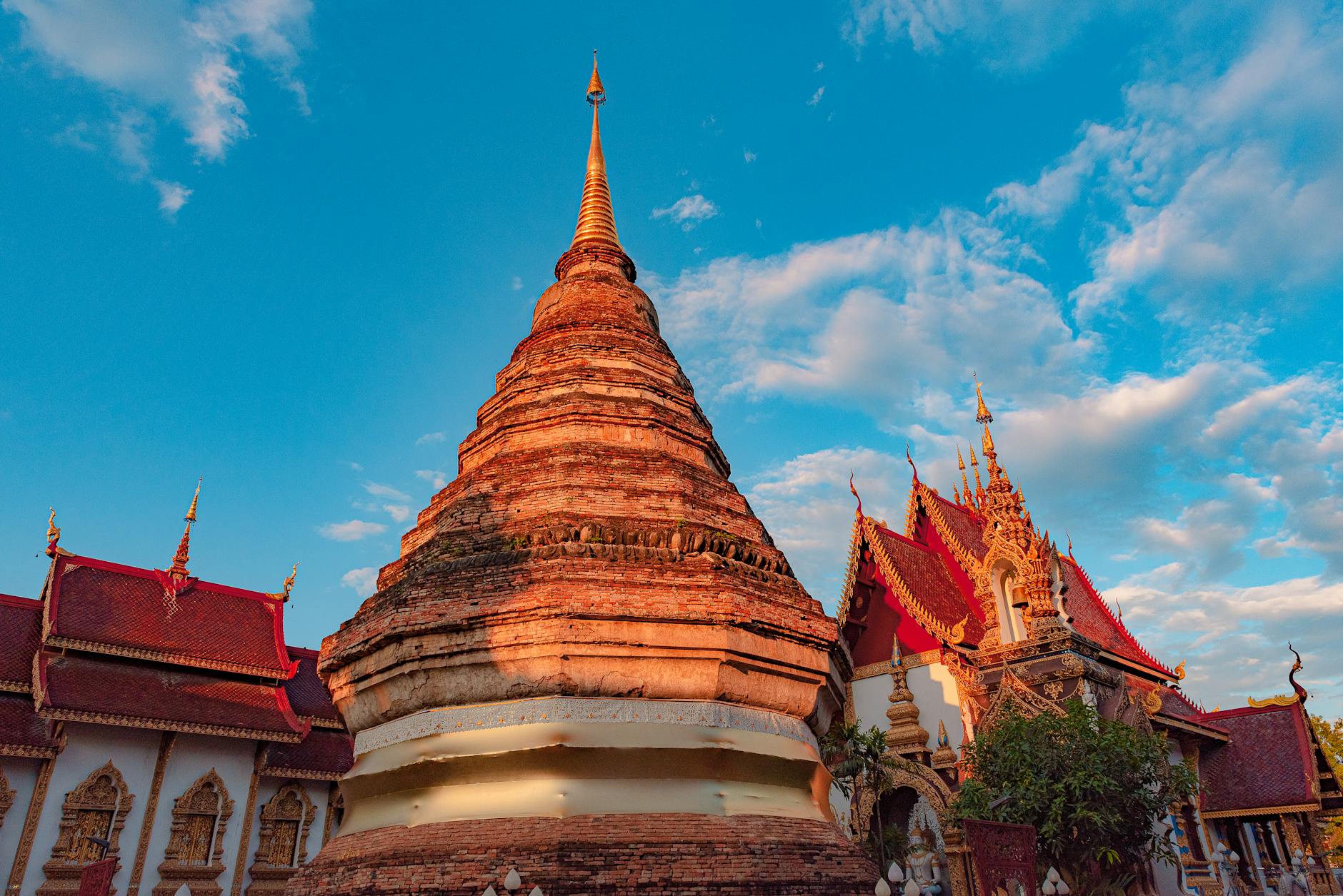 Stunning view of a traditional Buddhist temple against a bright blue sky in Chiang Mai, Thailand.