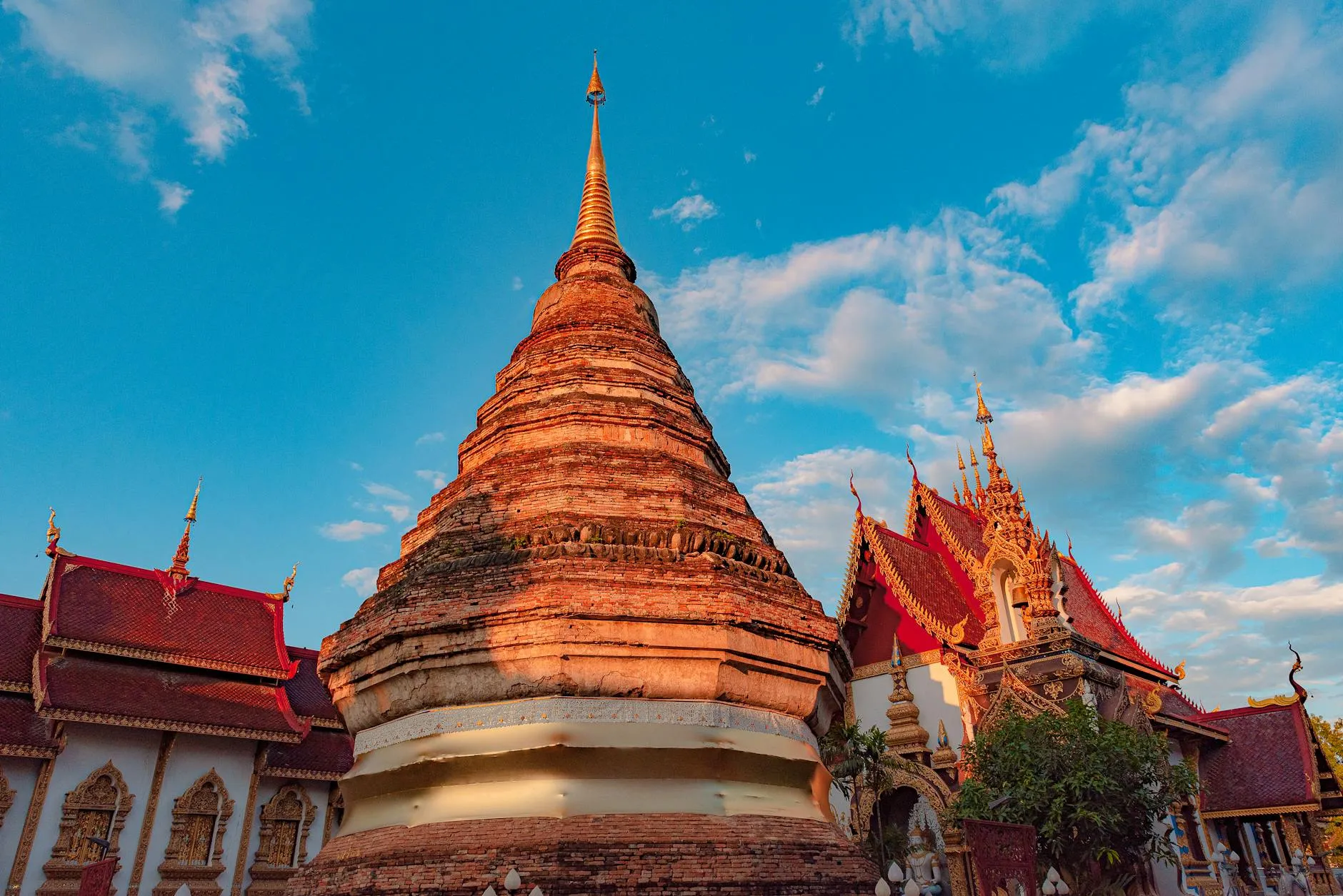 Stunning view of a traditional Buddhist temple against a bright blue sky in Chiang Mai, Thailand.