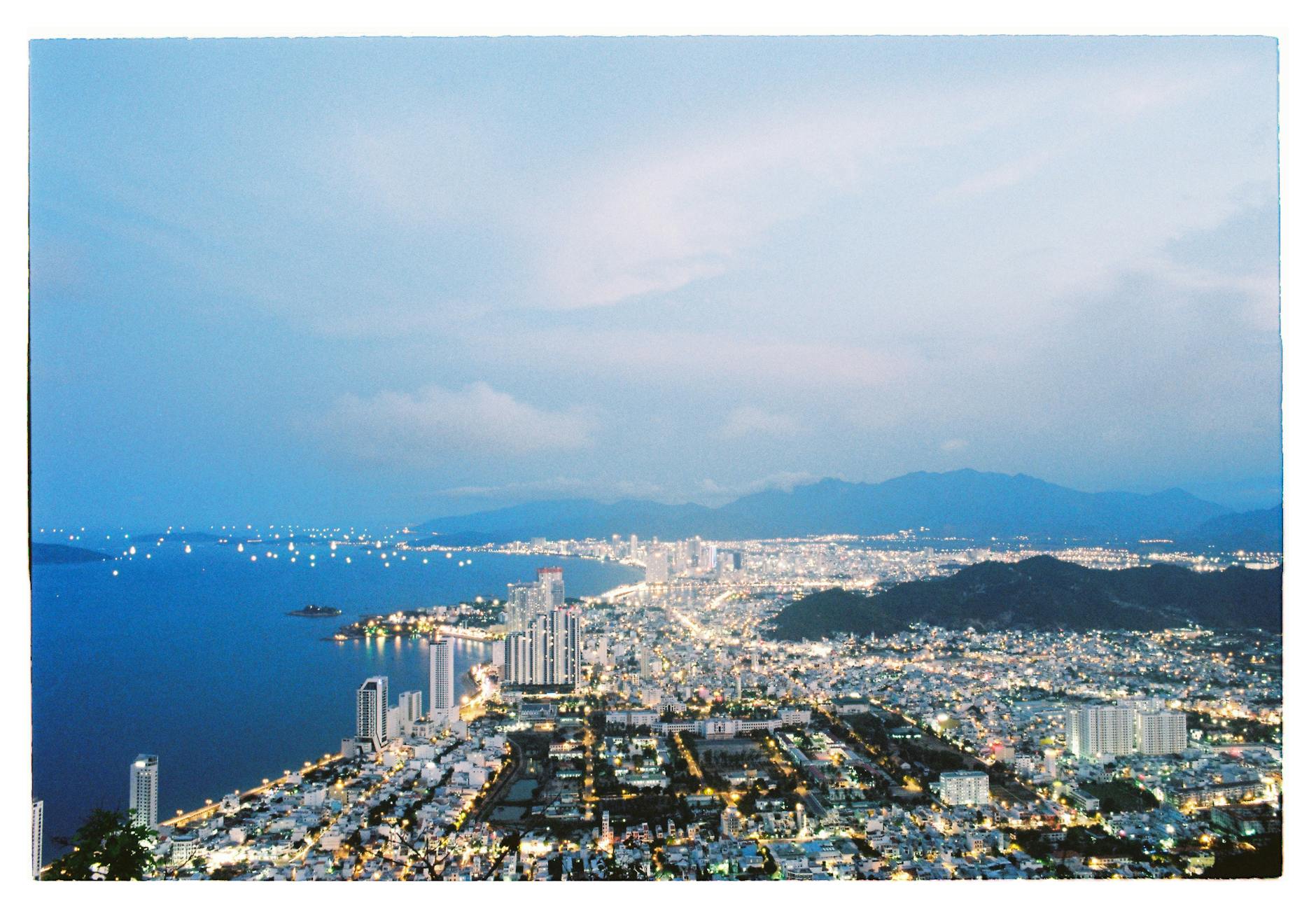 Nha Trang, Vietnam — Scenic aerial view of Nha Trang, Vietnam at dusk showcasing illuminated cityscape along the coast.