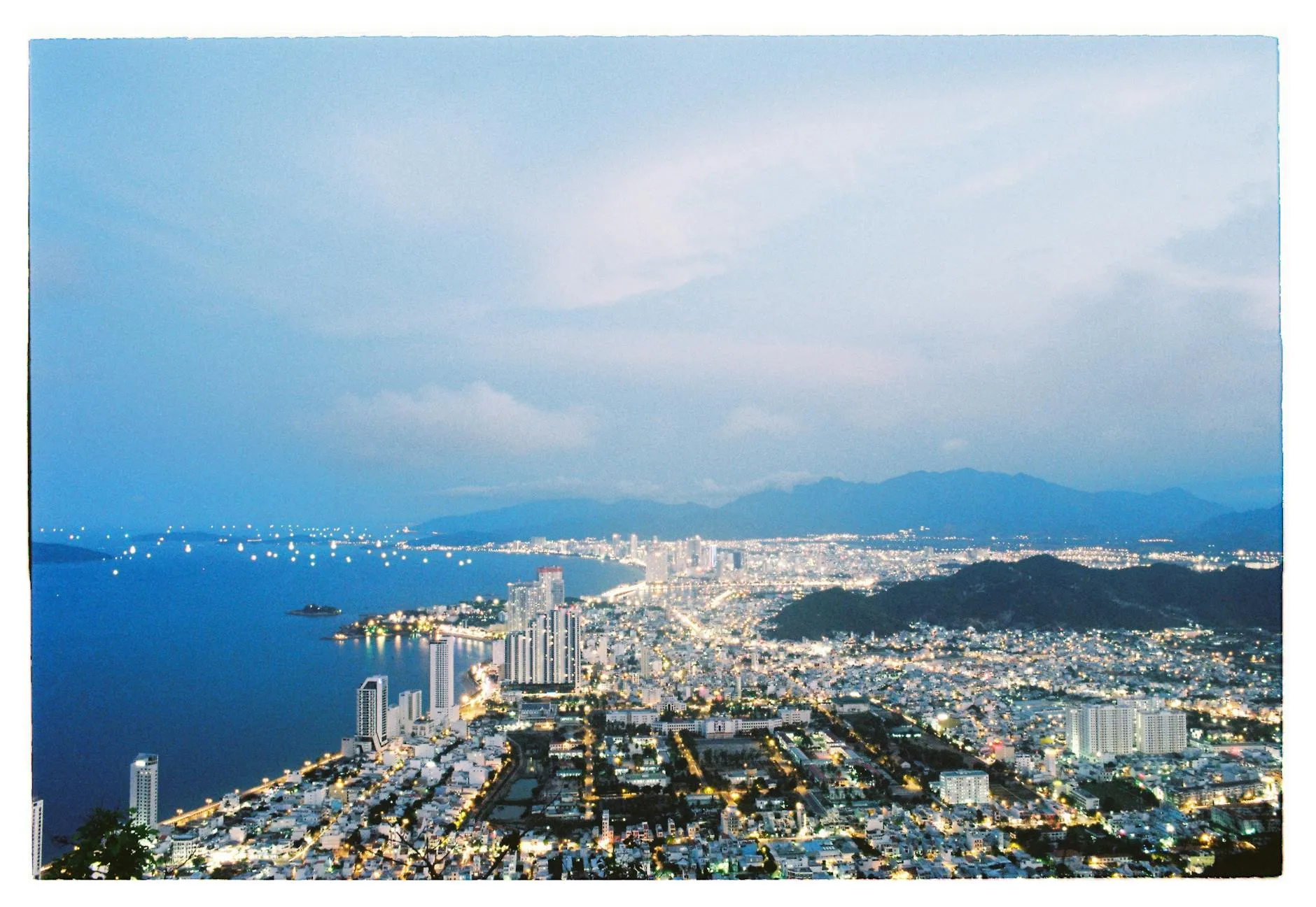 Nha Trang, Vietnam — Scenic aerial view of Nha Trang, Vietnam at dusk showcasing illuminated cityscape along the coast.