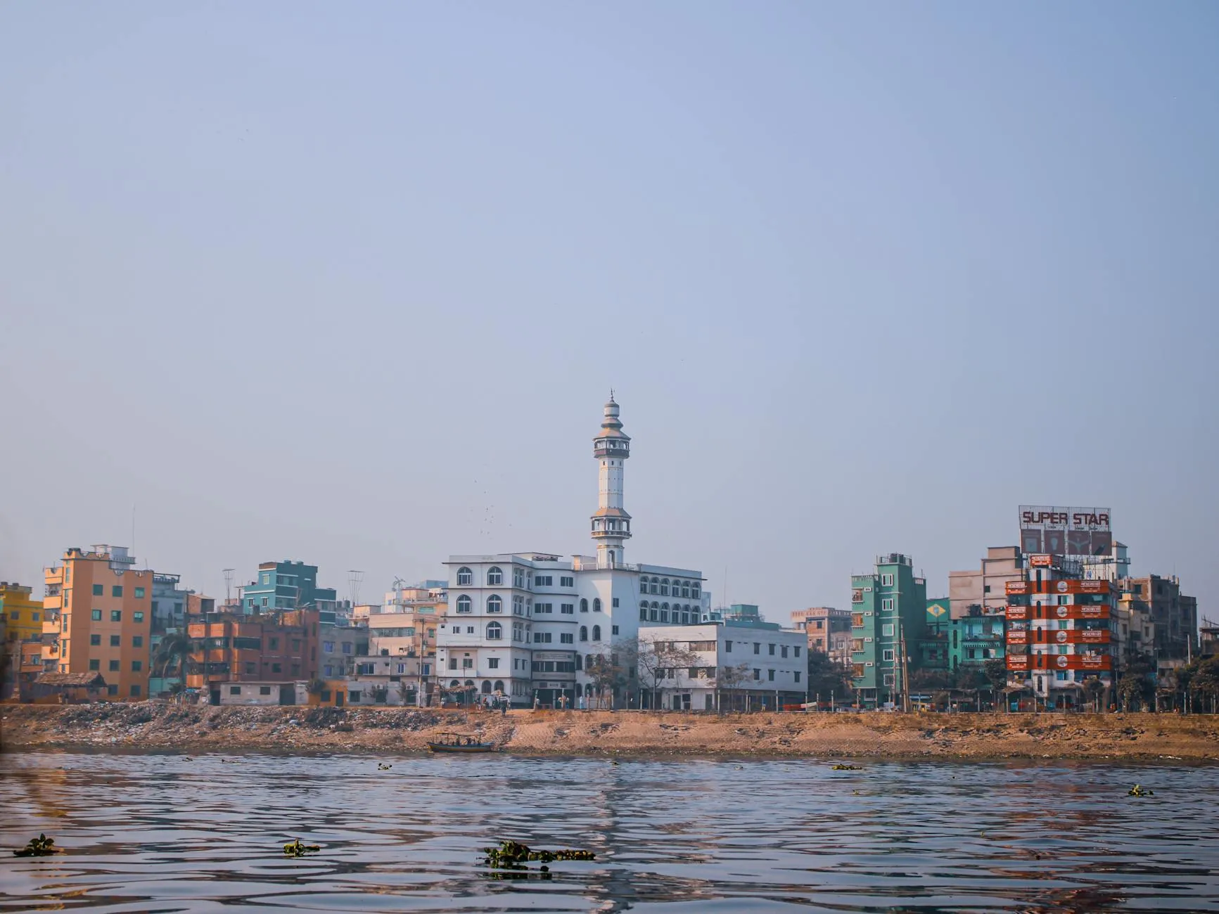 Dhaka Bangladesh — View of colorful buildings and mosque along riverbank in Dhaka, Bangladesh.