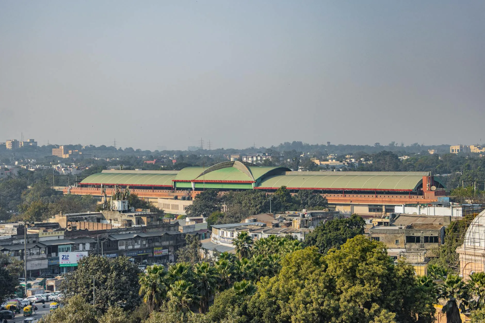 Panoramic aerial view of Pragati Maidan showcasing New Delhi's urban skyline under clear skies.