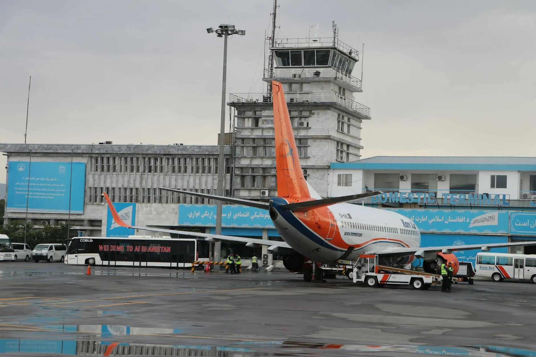 Airplane at Kabul Airport's domestic terminal with visible tower.