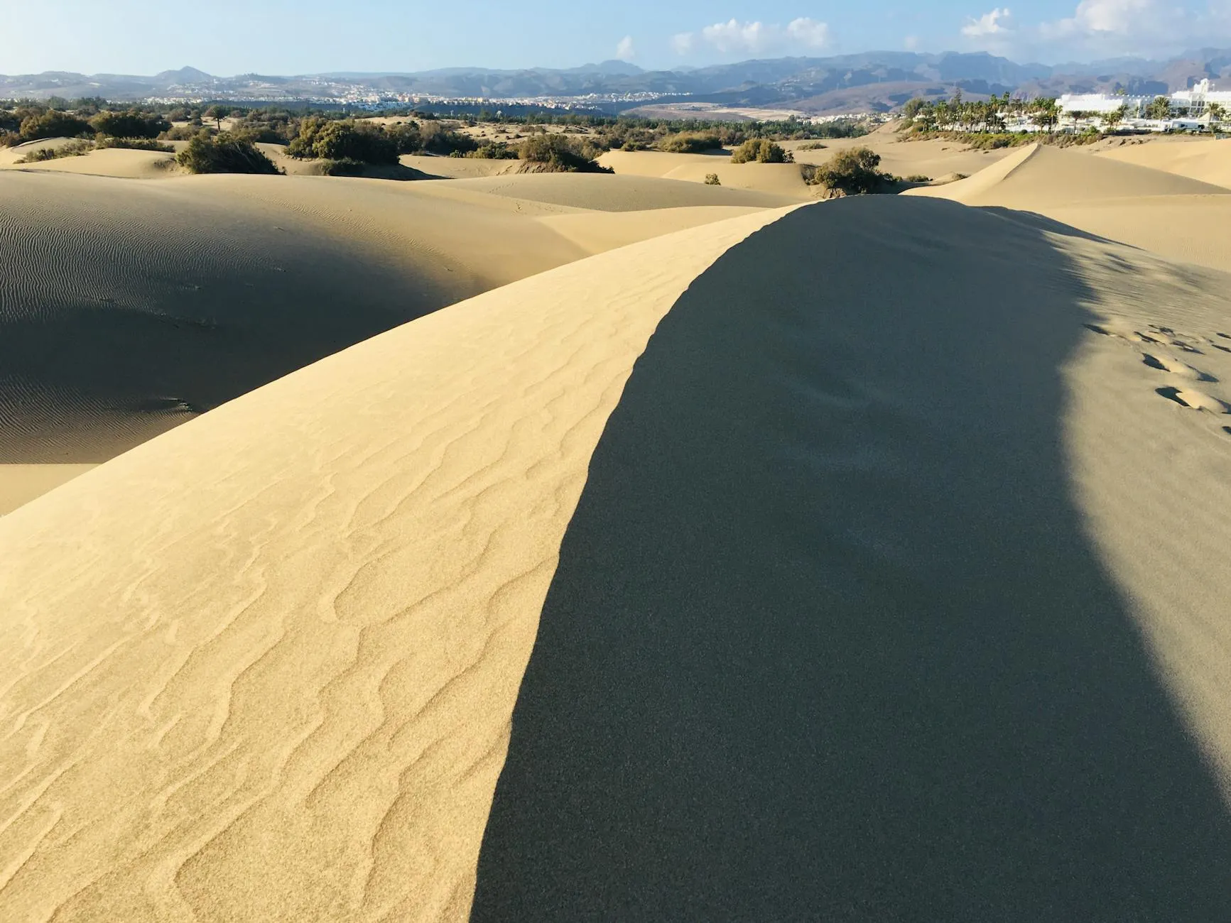 Stunning view of the Maspalomas sand dunes in Gran Canaria under a clear blue sky.