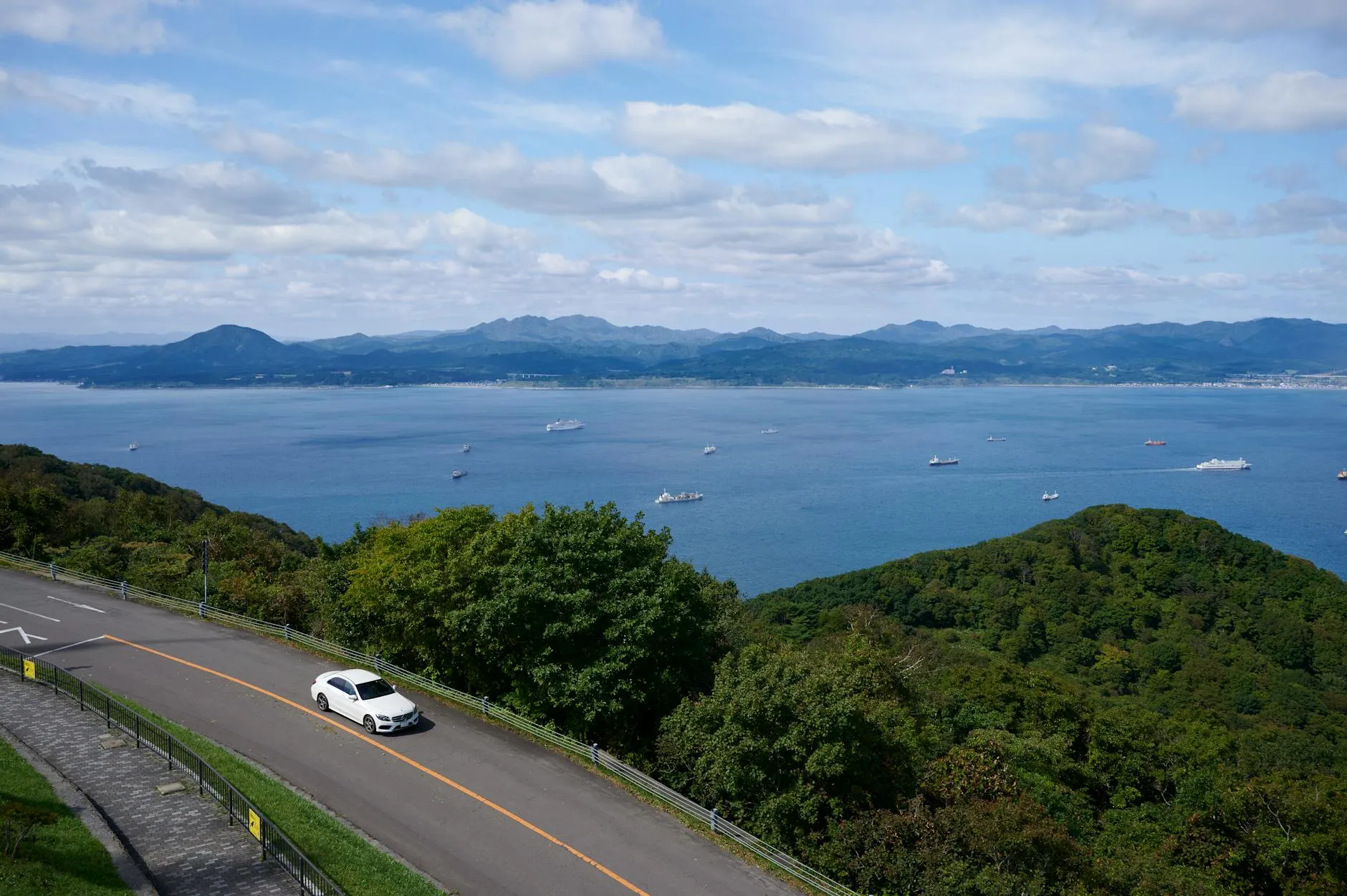 Hakodate, Japan — Aerial view of a car on a road overlooking Hakodate's coastline and sea in Hokkaido, Japan.
