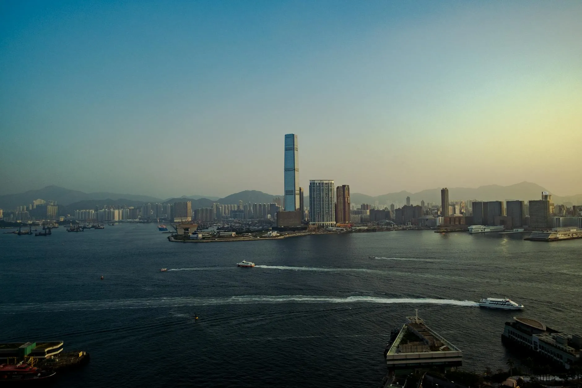 Captivating aerial view of Hong Kong's skyline with a tranquil waterfront at dusk.