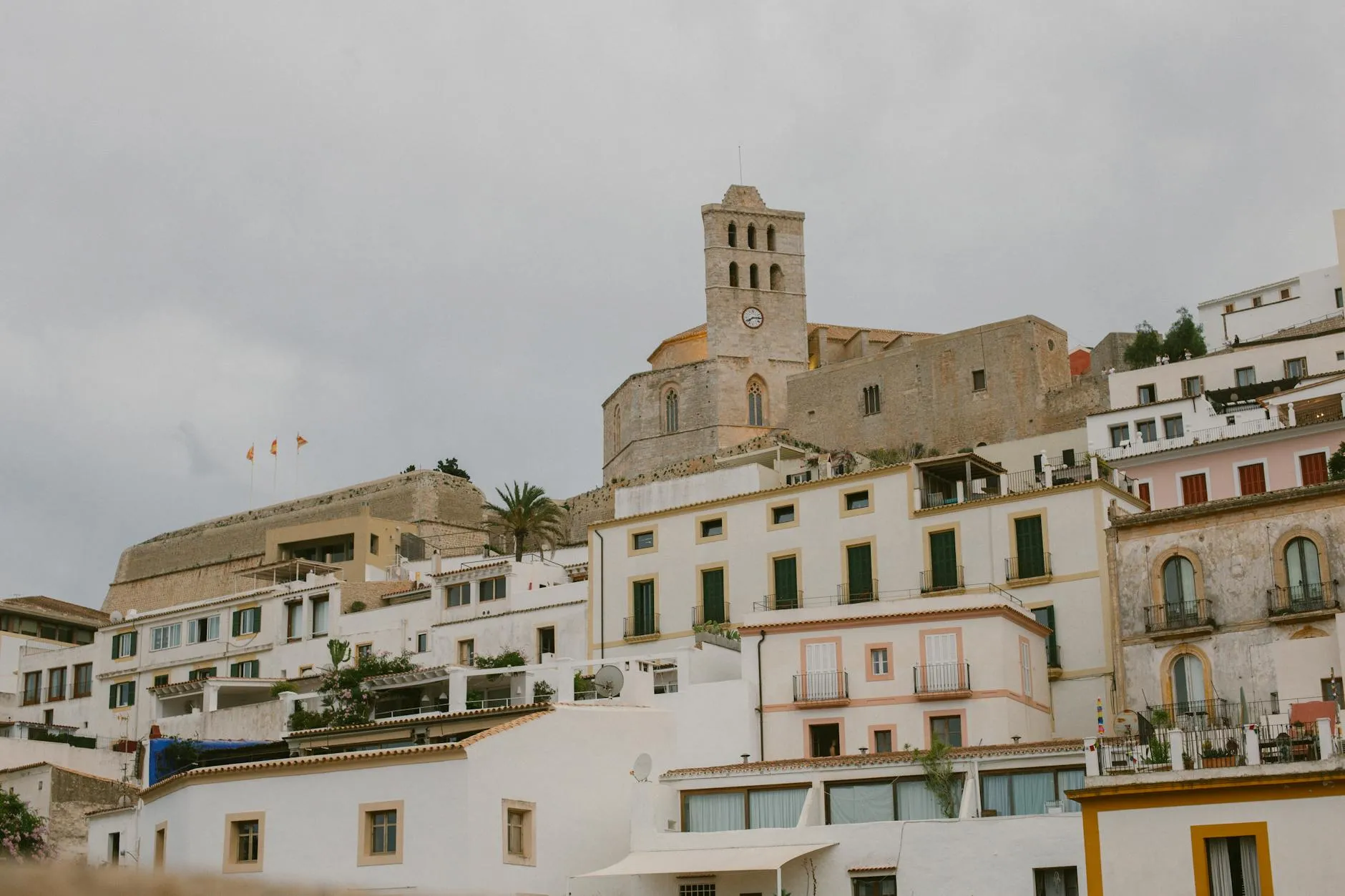 A picturesque view of Ibiza's iconic church and old town architecture on a cloudy day.