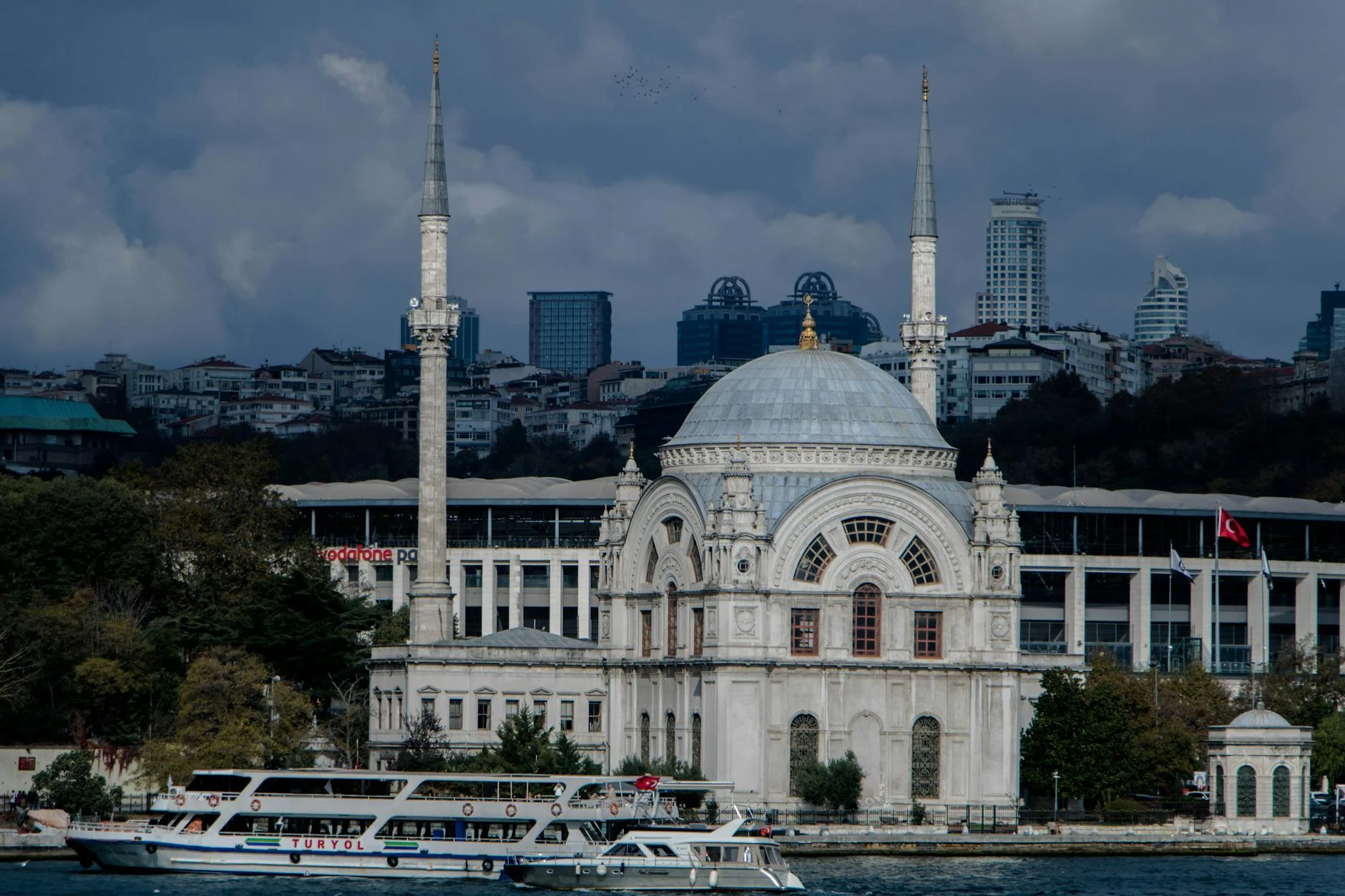Scenic view of Ortaköy Mosque by the Bosphorus in Istanbul, showcasing a blend of history and modern cityscape.