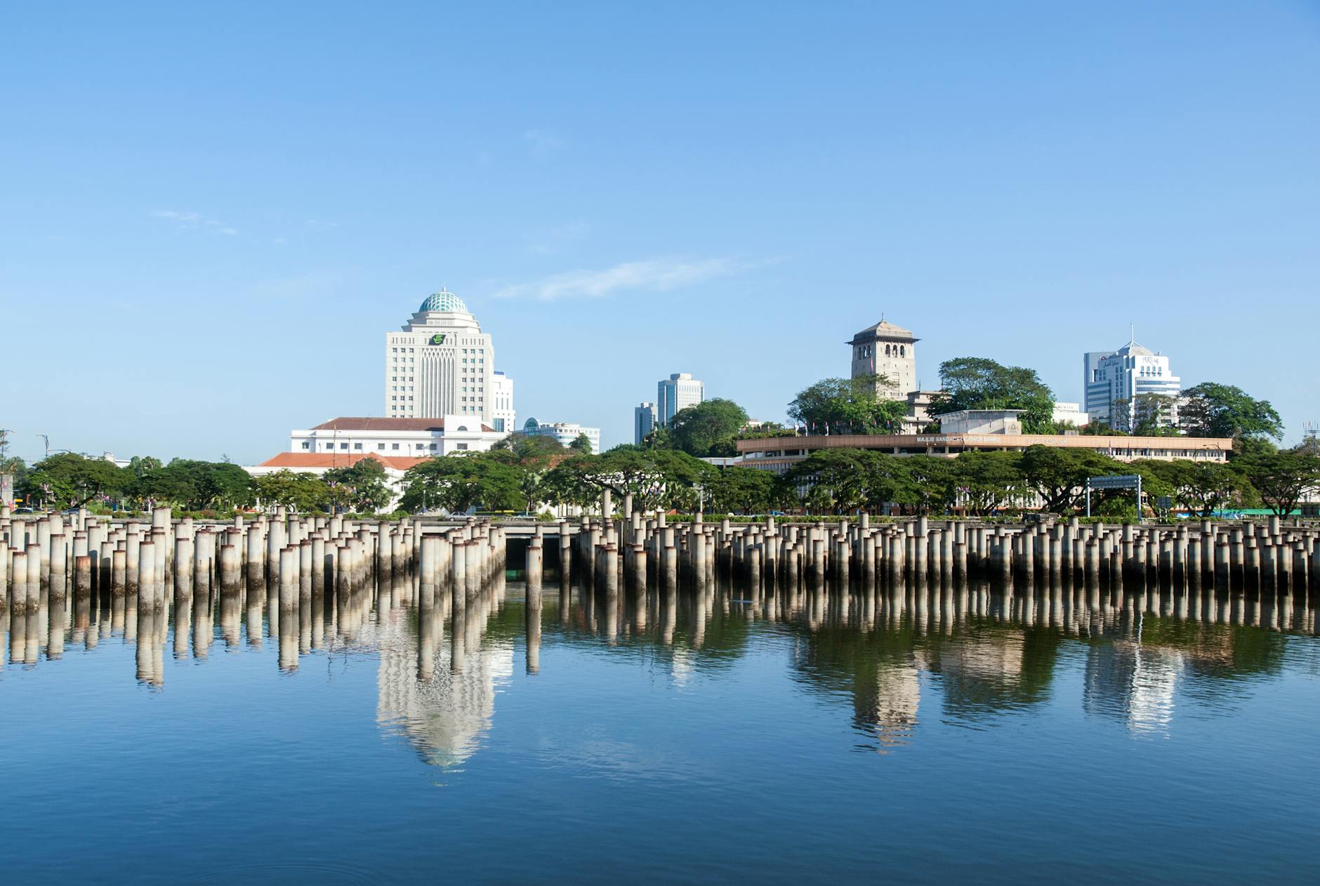 Johor Bahru, Malaysia — Beautiful view of Johor Bahru skyline reflecting on calm water on a sunny day.