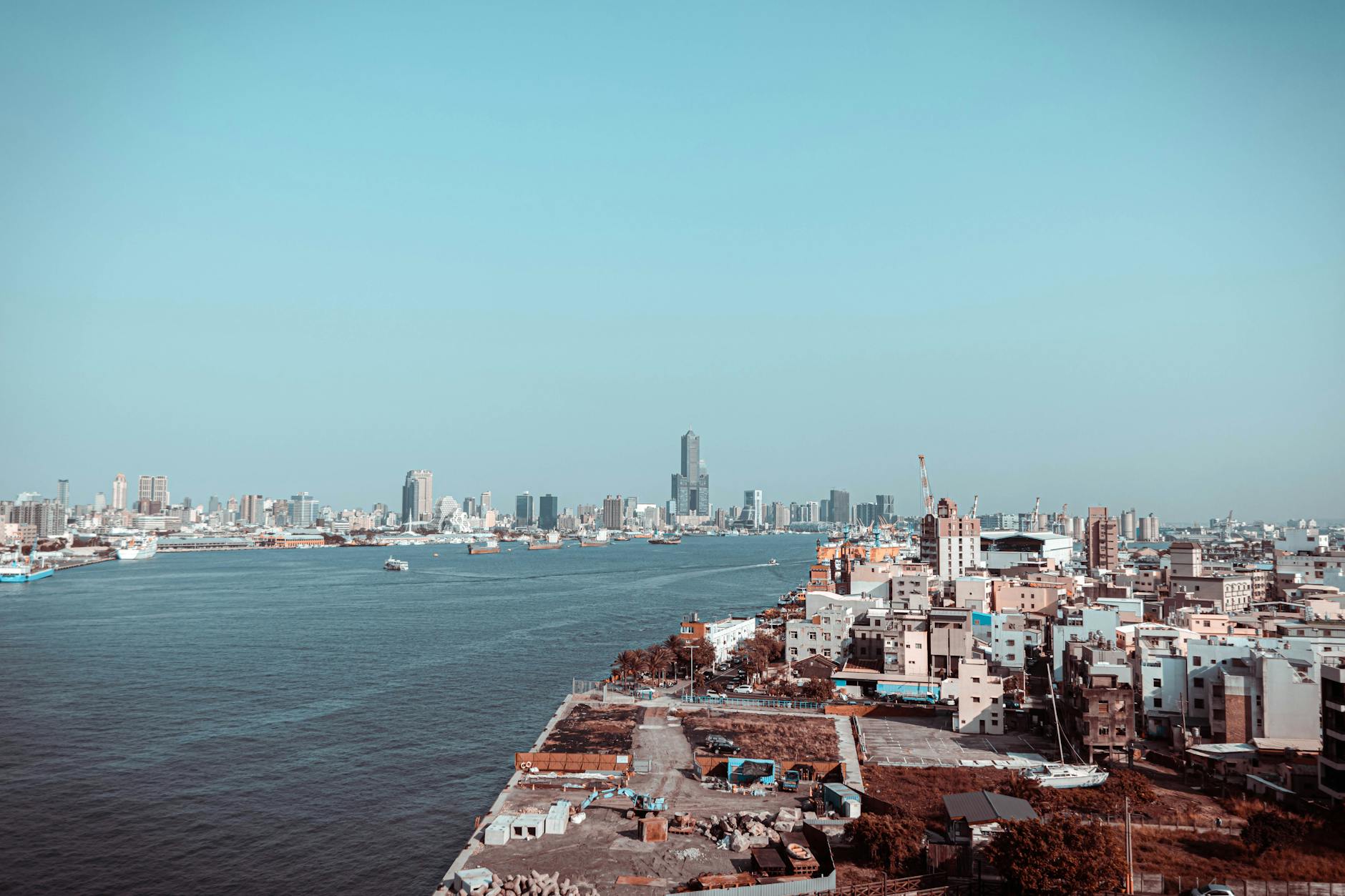 A stunning aerial view of Kaohsiung City skyline with ocean in the foreground.