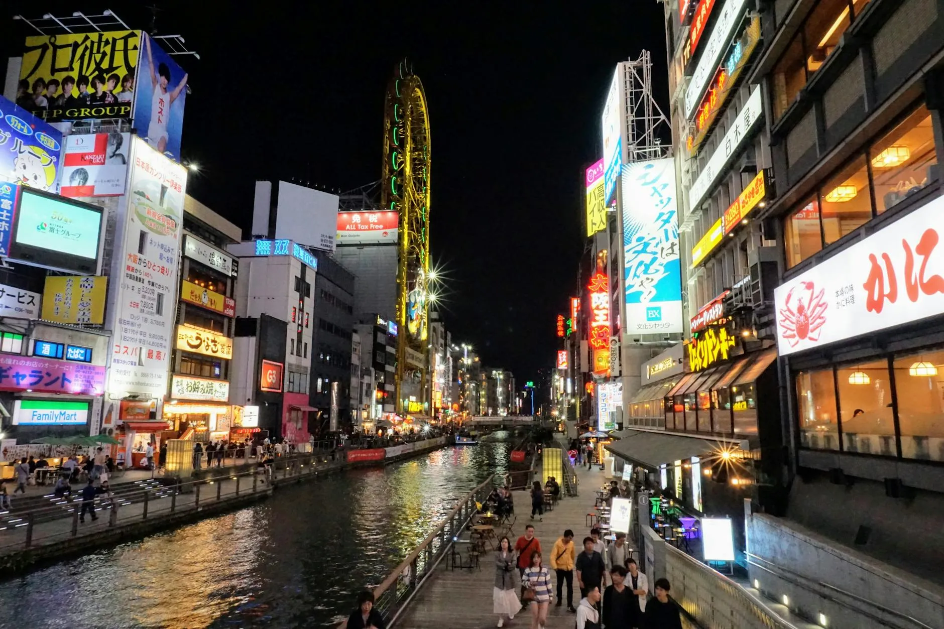 Osaka Japan — Nighttime view of Dotonbori Canal in Osaka, Japan, with bustling crowds and neon lights.