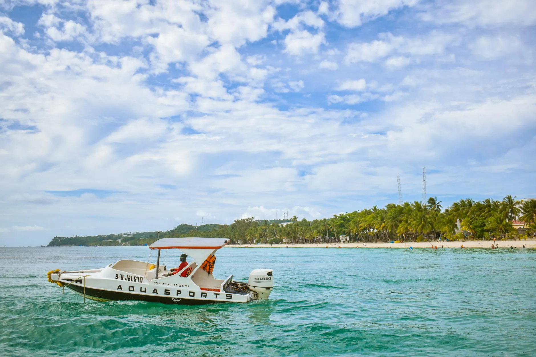 Boracay, Philippines — A bright summer scene showing a speedboat cruising near Boracay's white sand beach, Philippines.