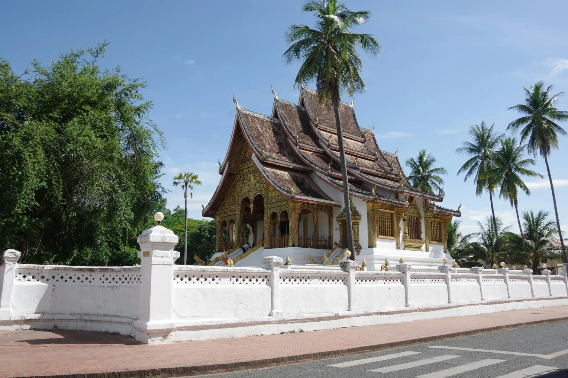 Luang Prabang, Laos — Explore the Royal Palace's intricate architecture surrounded by lush palms in Luang Prabang, Laos.