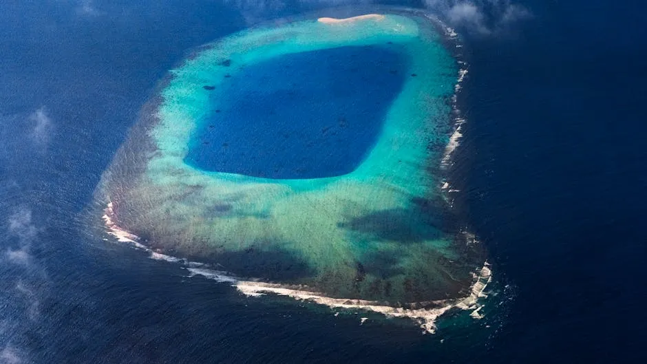 Stunning aerial view of a turquoise lagoon surrounded by vibrant blue ocean and white sandy shores.