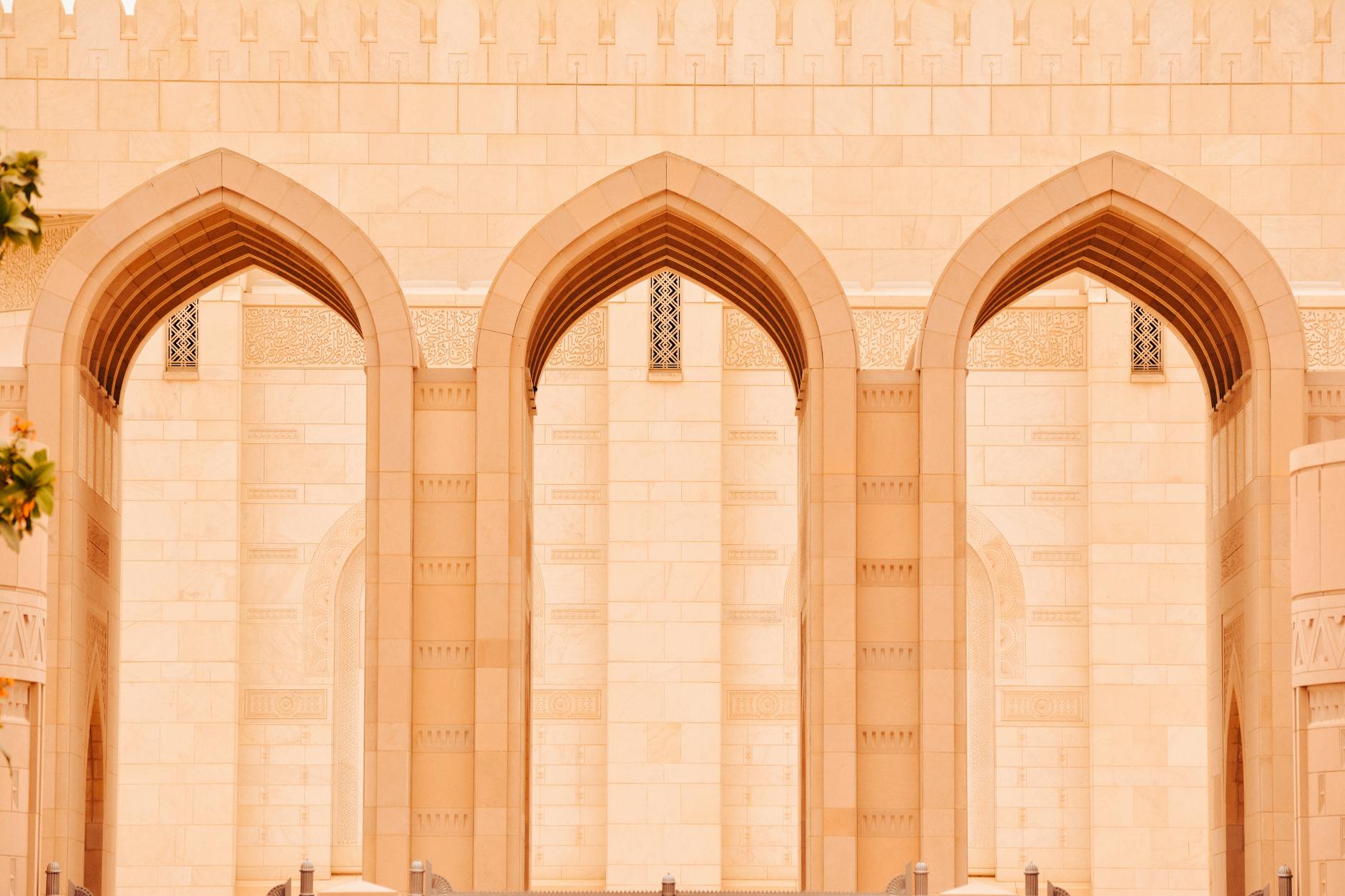 Muscat International Airport (MCT) — Close-up of elegant arches at the Sultan Qaboos Grand Mosque in Muscat, Oman.