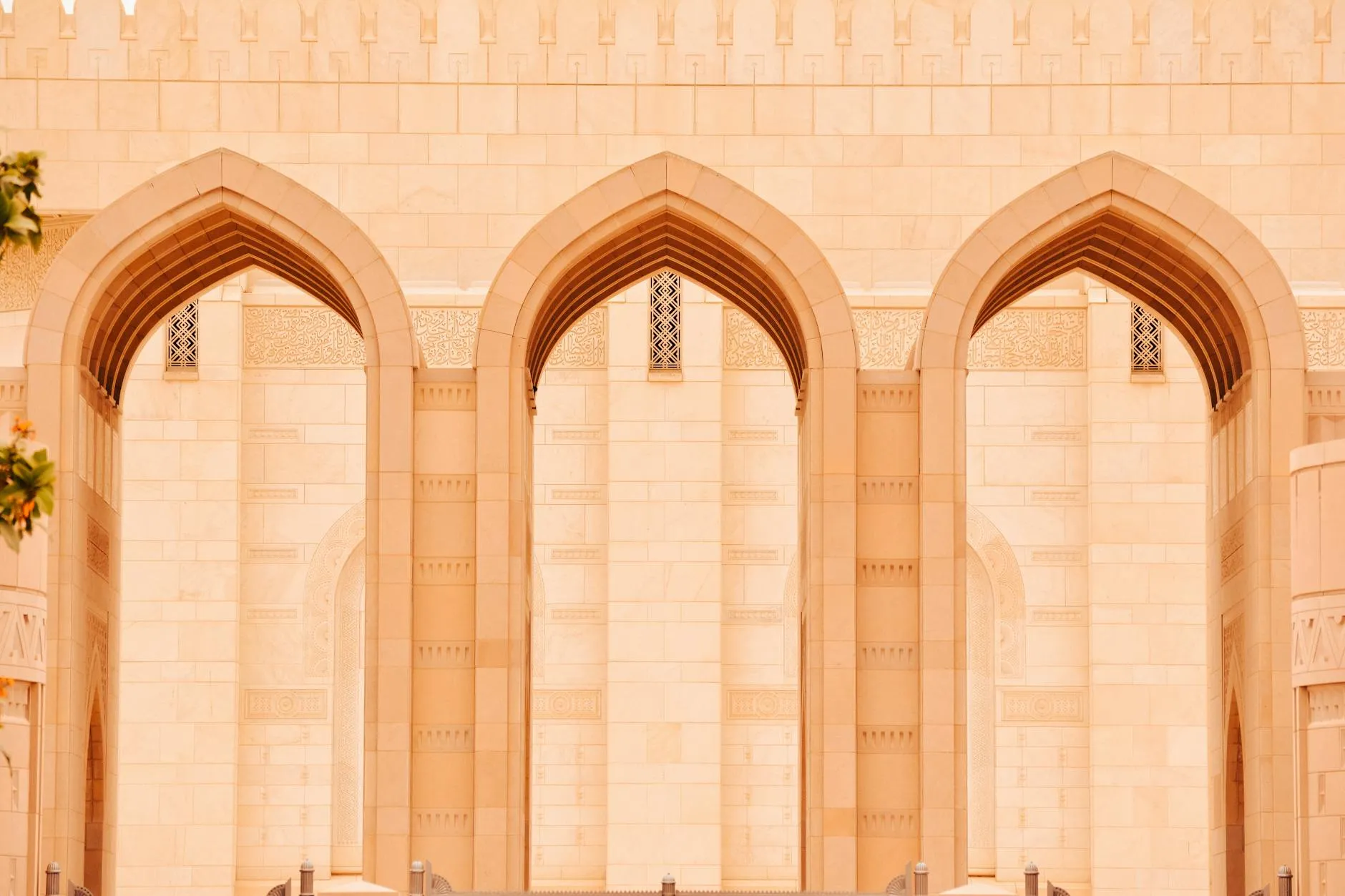 Muscat International Airport (MCT) — Close-up of elegant arches at the Sultan Qaboos Grand Mosque in Muscat, Oman.