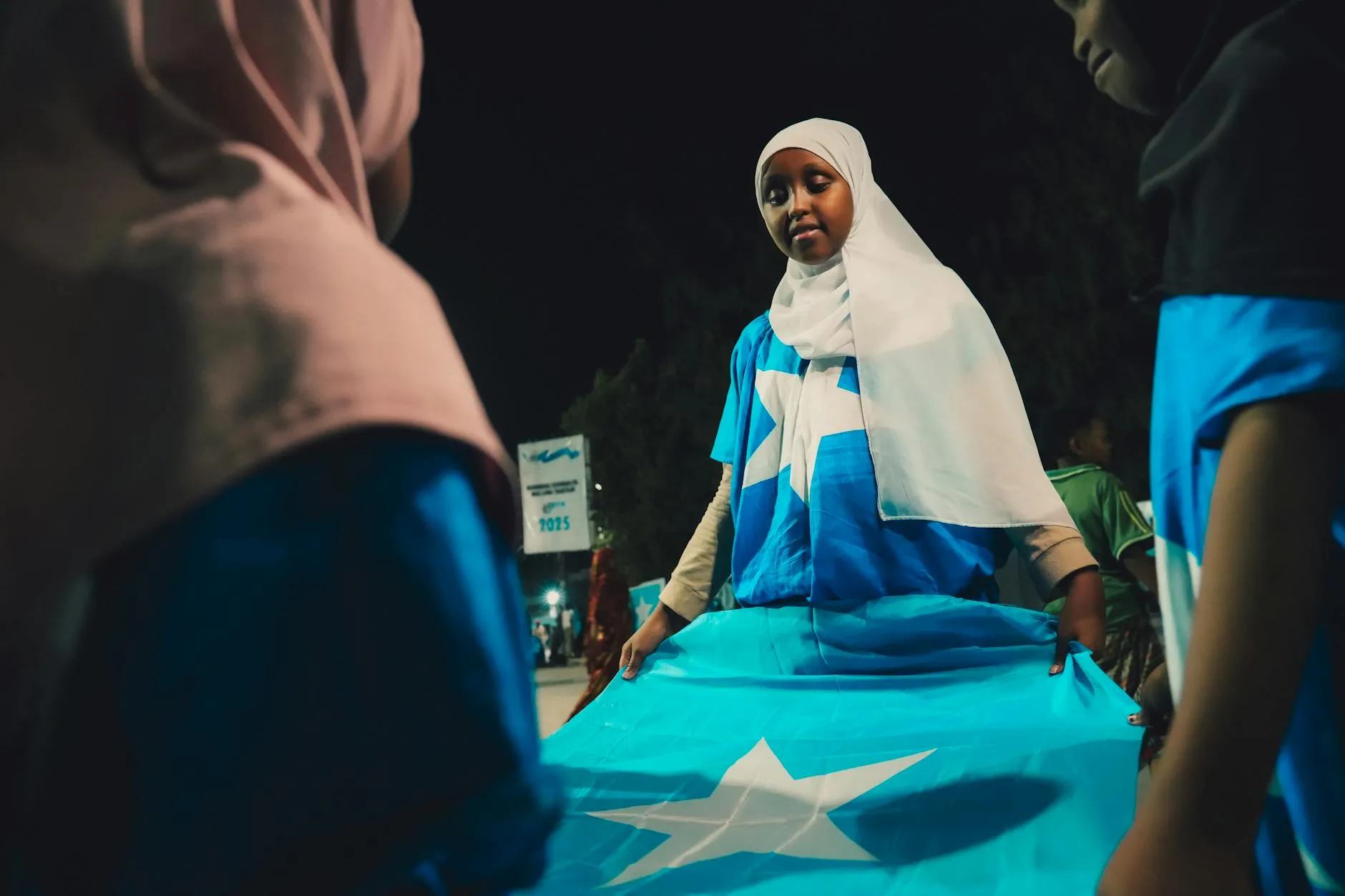 Mogadishu Somalia — Young person holding the Somalia flag during a night celebration in Mogadishu. Patriotic spirit in Banaadir region.