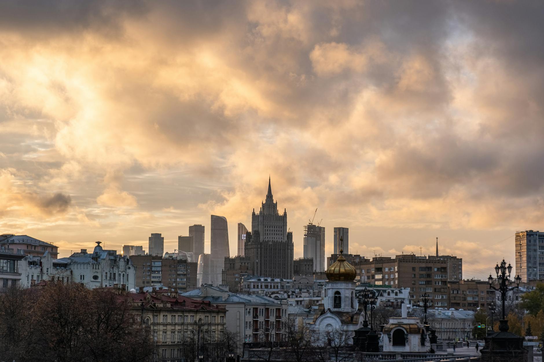 Urban cityscape of Moscow with dramatic clouds at sunset highlighting the skyline and architecture.