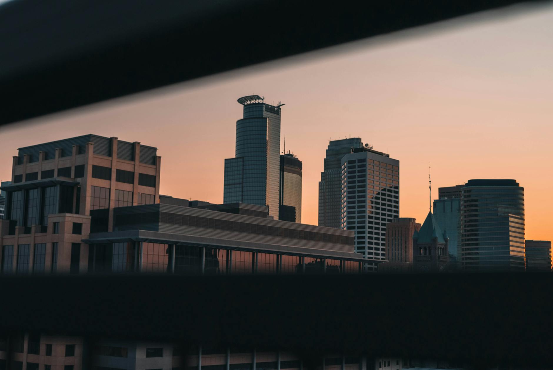 Minneapolis-Saint Paul International Airport (MSP) — Captivating view of Minneapolis skyline during sunset, showcasing modern architecture in a serene twilight.