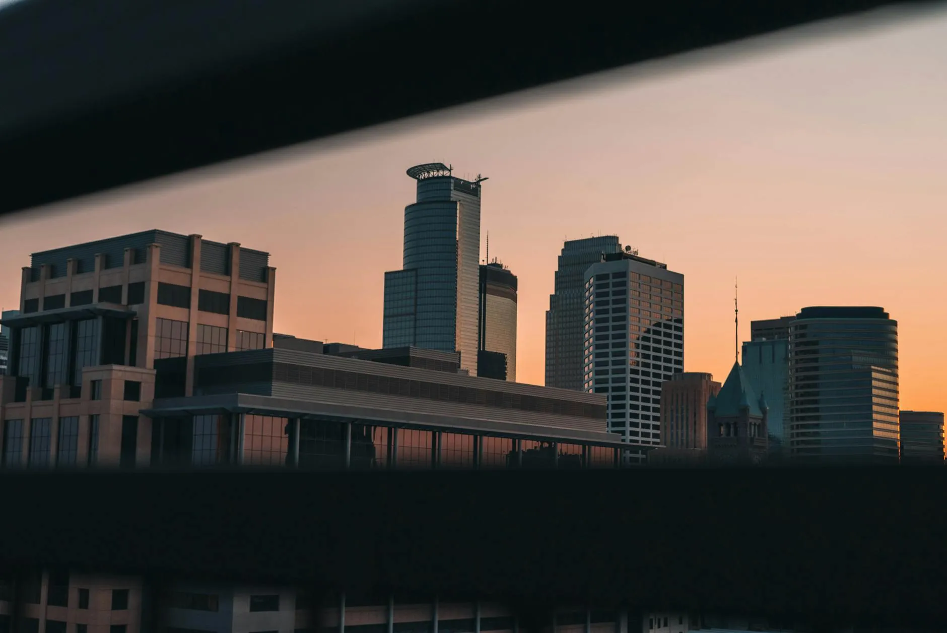 Minneapolis-Saint Paul International Airport (MSP) — Captivating view of Minneapolis skyline during sunset, showcasing modern architecture in a serene twilight.