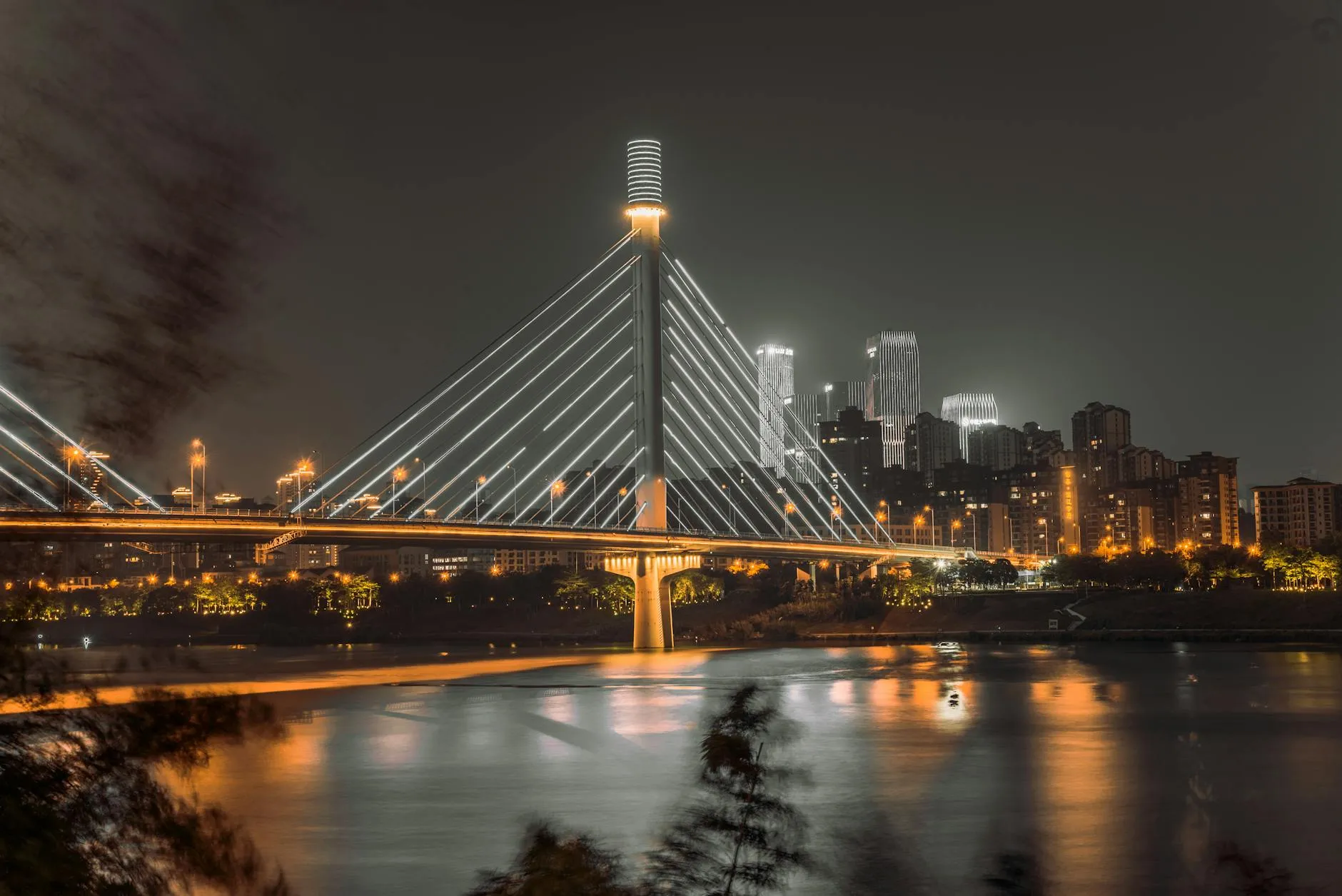 Nanning, China — Captivating night view of a modern cable-stayed bridge in Nanning, Guangxi with city skyline.