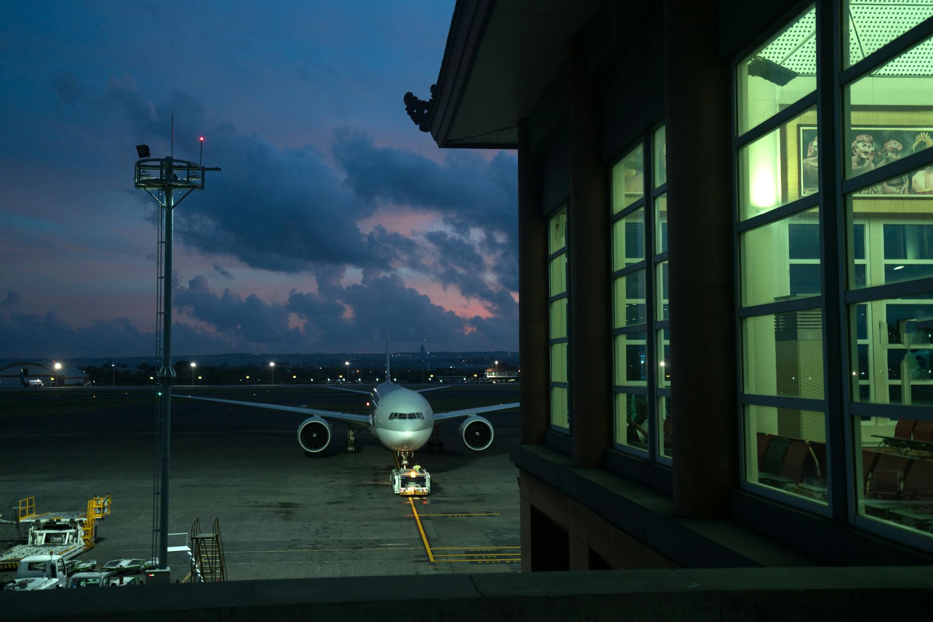 Modern plane parking on stand near assigned gate in modern airport terminal at night