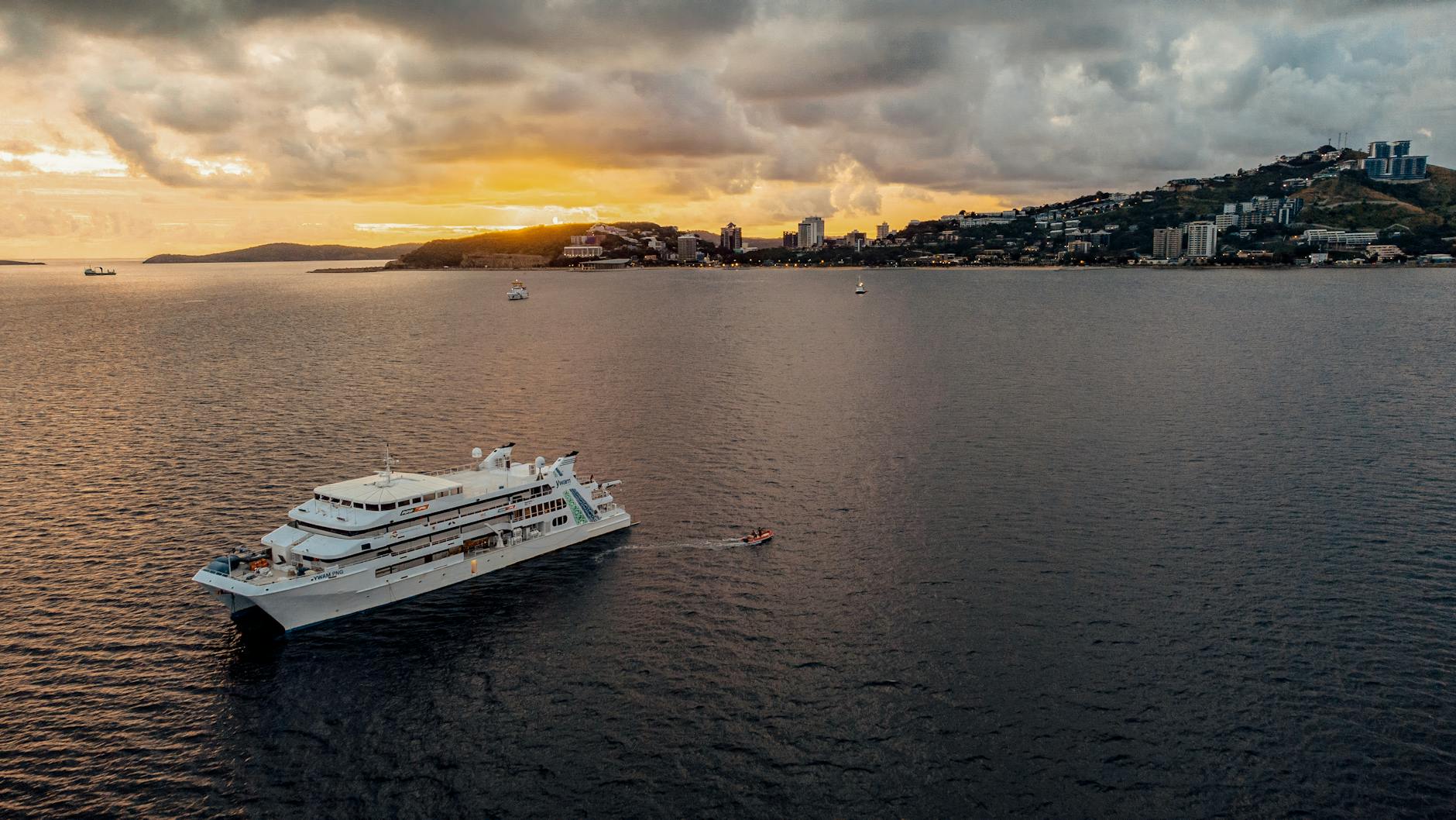Port Moresby, Papua New Guinea — A cruise ship sails in Port Moresby harbor at sunset, Papua New Guinea.