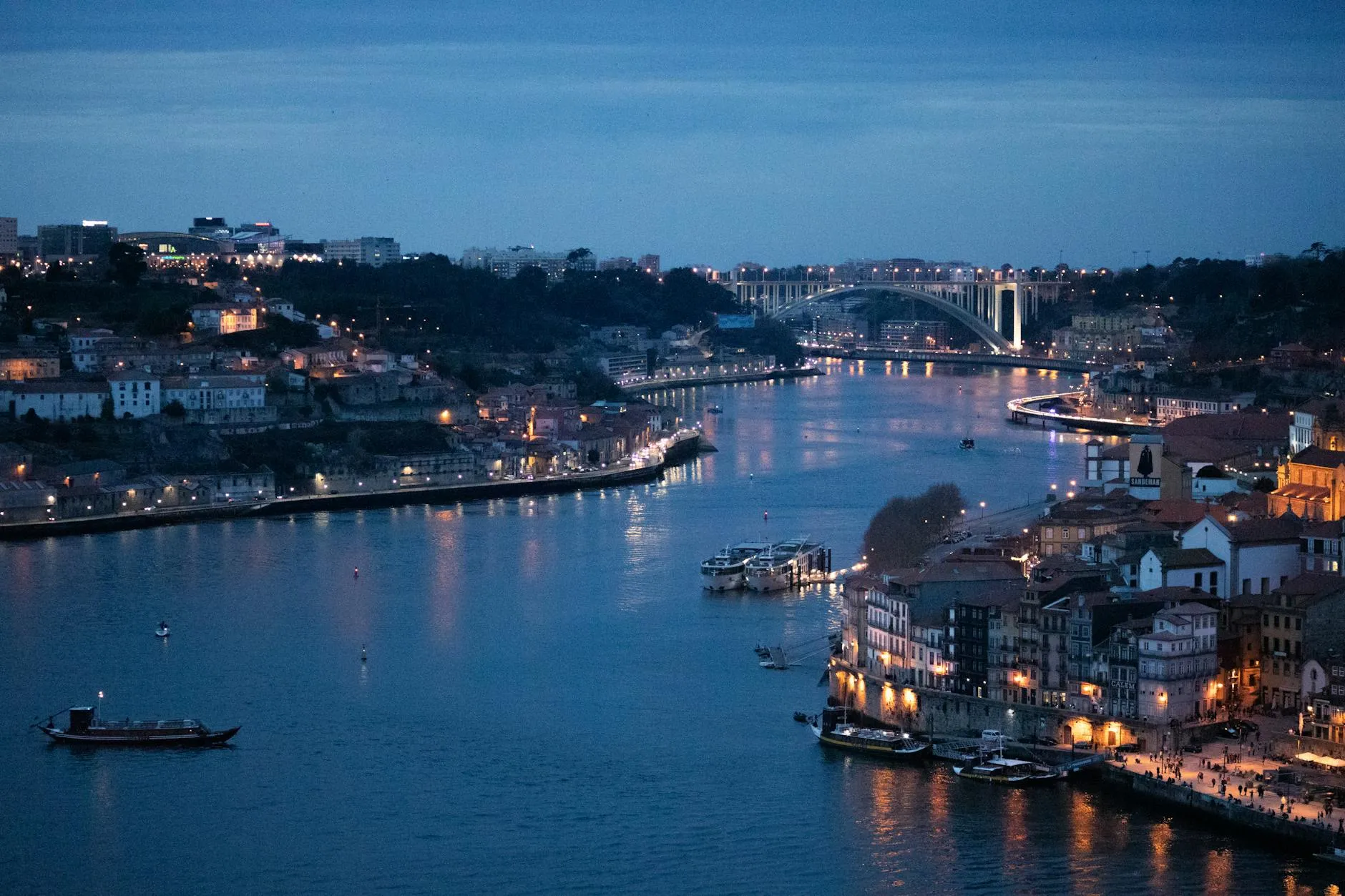 Captivating evening view of Porto's Douro River with illuminated bridges and city lights.