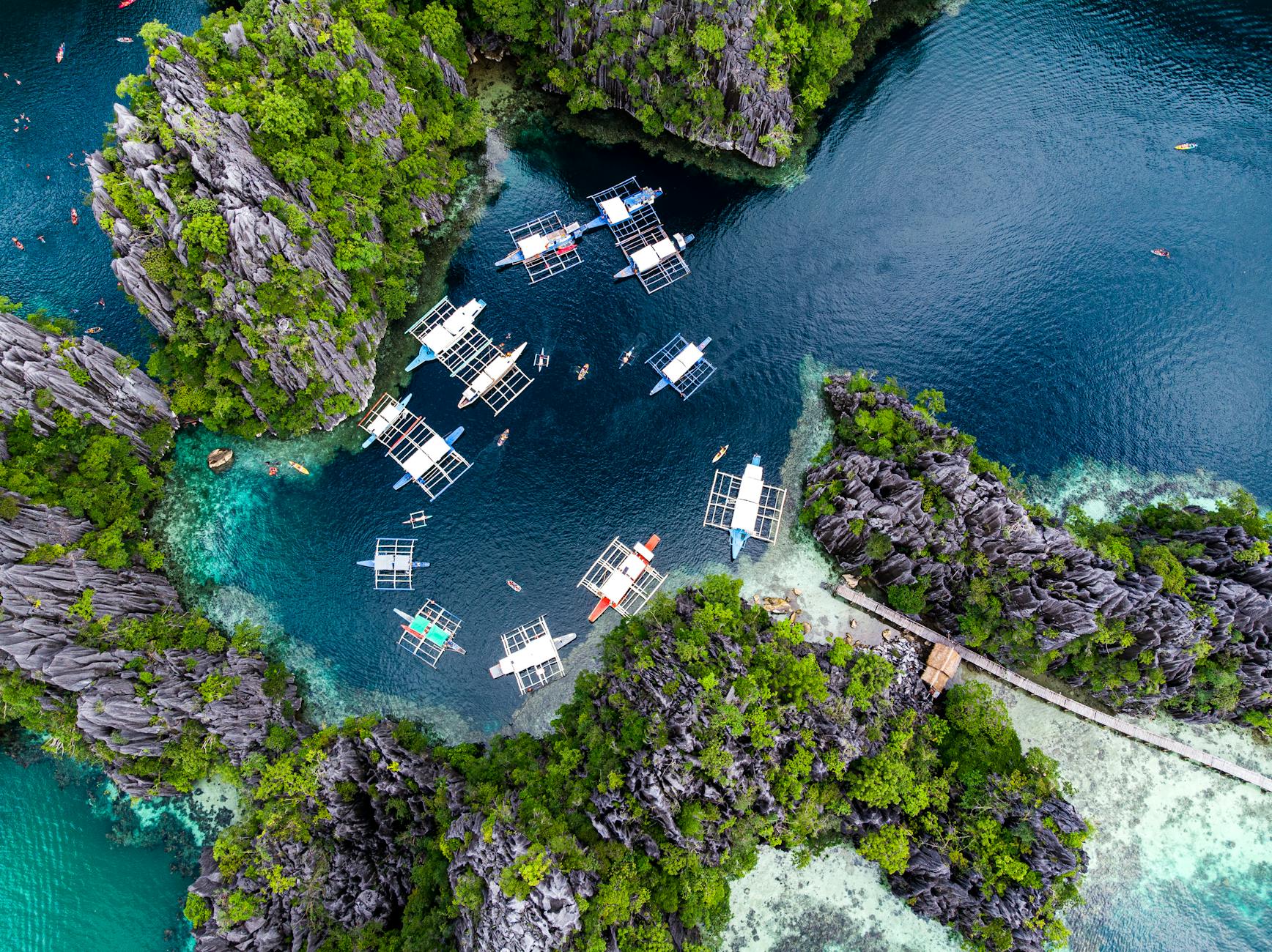 Palawan, Philippines — Stunning aerial shot of boats in a turquoise lagoon surrounded by rock formations in El Nido, Palawan, Philippines.