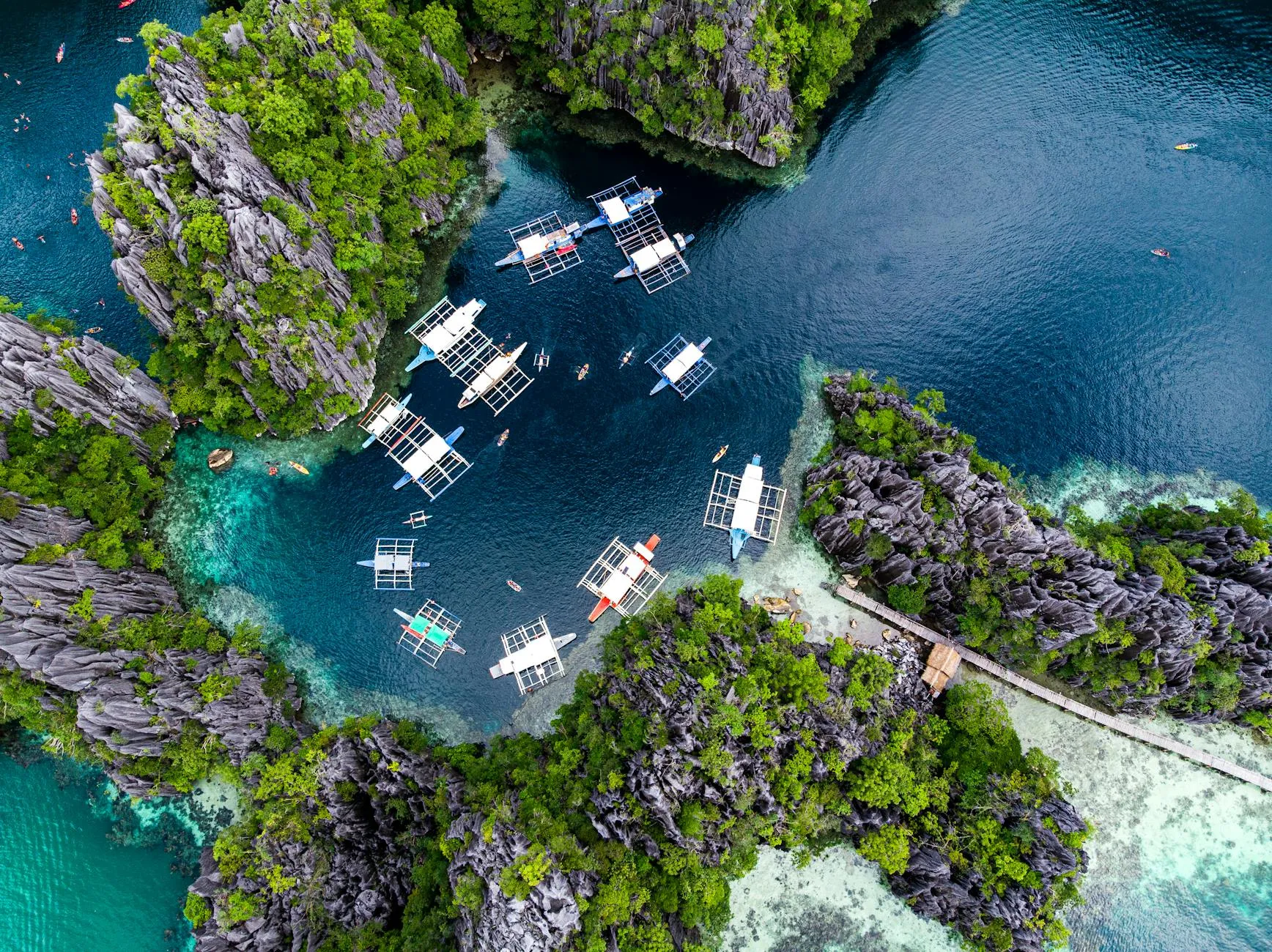 Palawan, Philippines — Stunning aerial shot of boats in a turquoise lagoon surrounded by rock formations in El Nido, Palawan, Philippines.