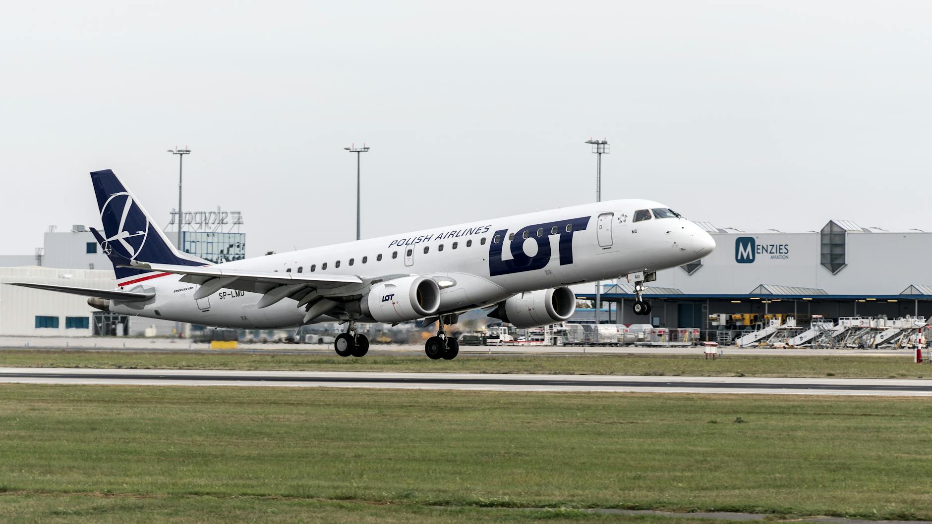 A LOT Polish Airlines airplane ascending from Prague airport, showcasing aviation and travel themes.