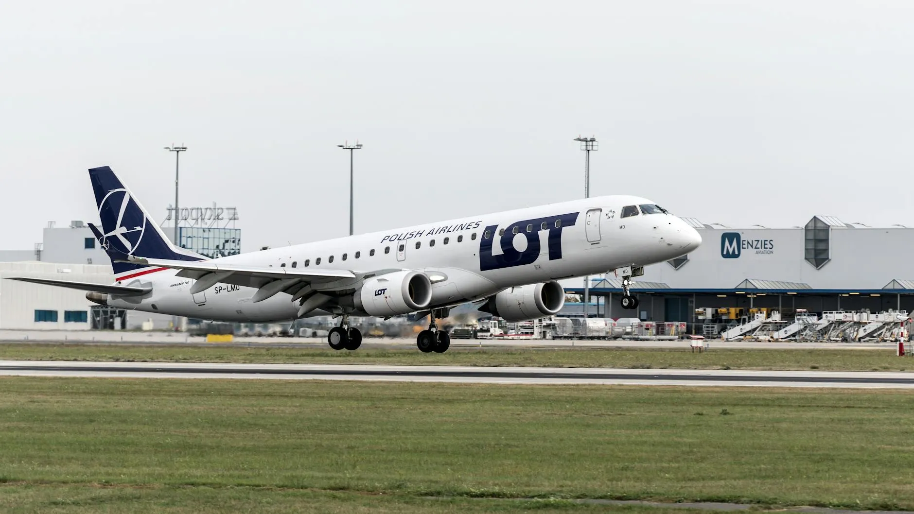 A LOT Polish Airlines airplane ascending from Prague airport, showcasing aviation and travel themes.