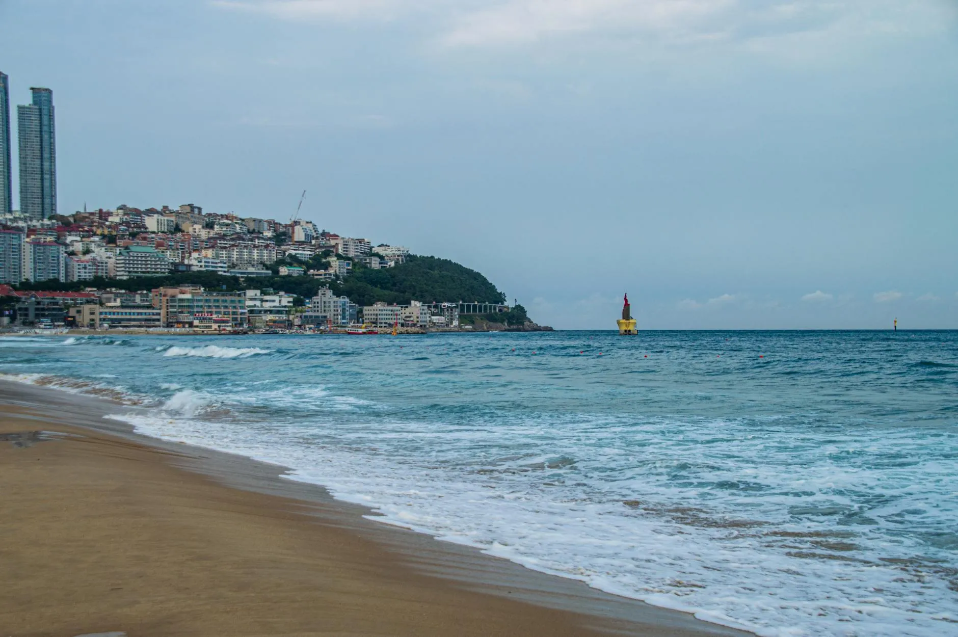 Busan, South Korea — Tranquil scene of Haeundae Beach with city skyline and ocean in Busan, South Korea.