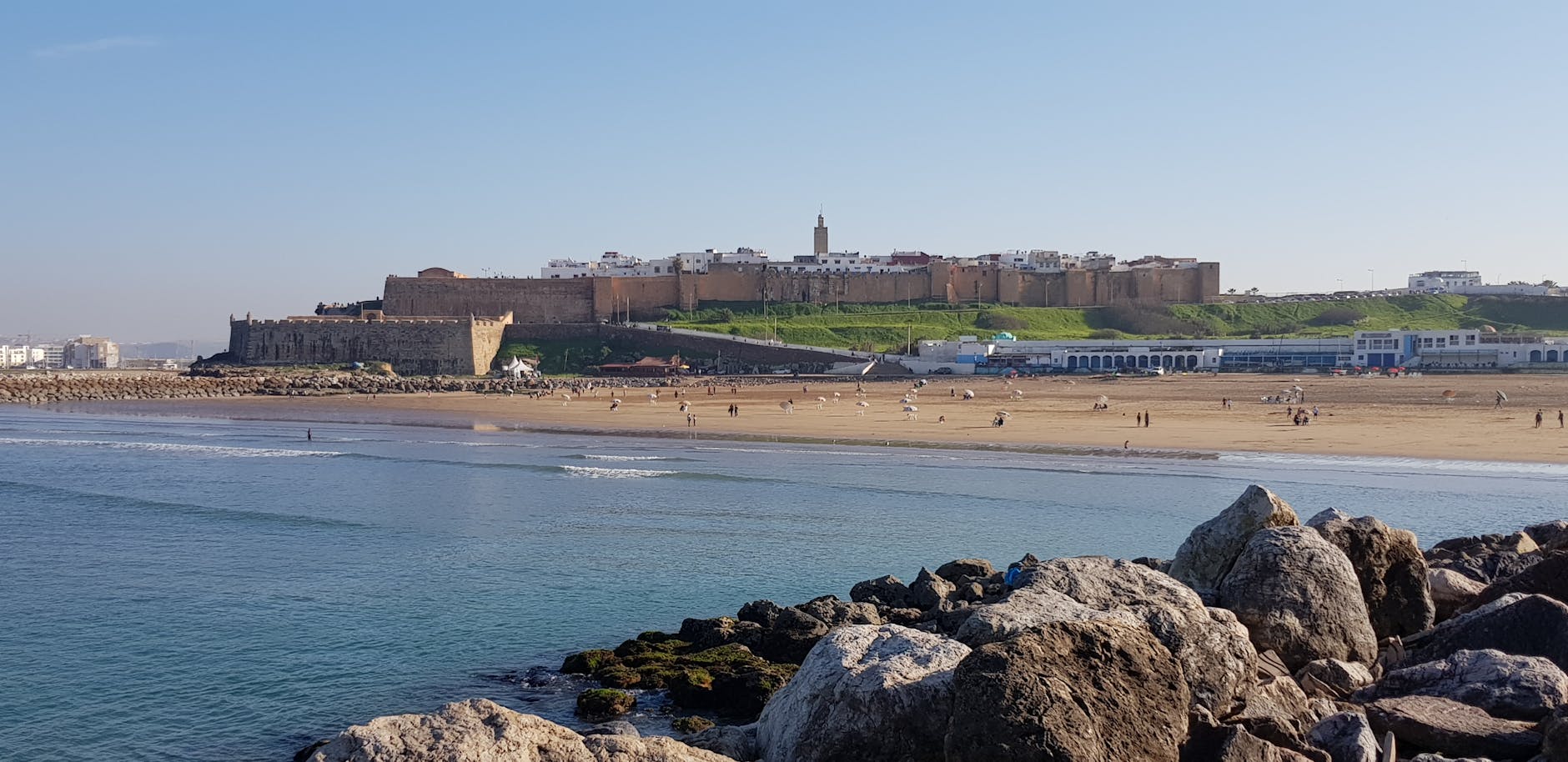 Scenic view of Rabat beach, fortress, and Atlantic Ocean waves.