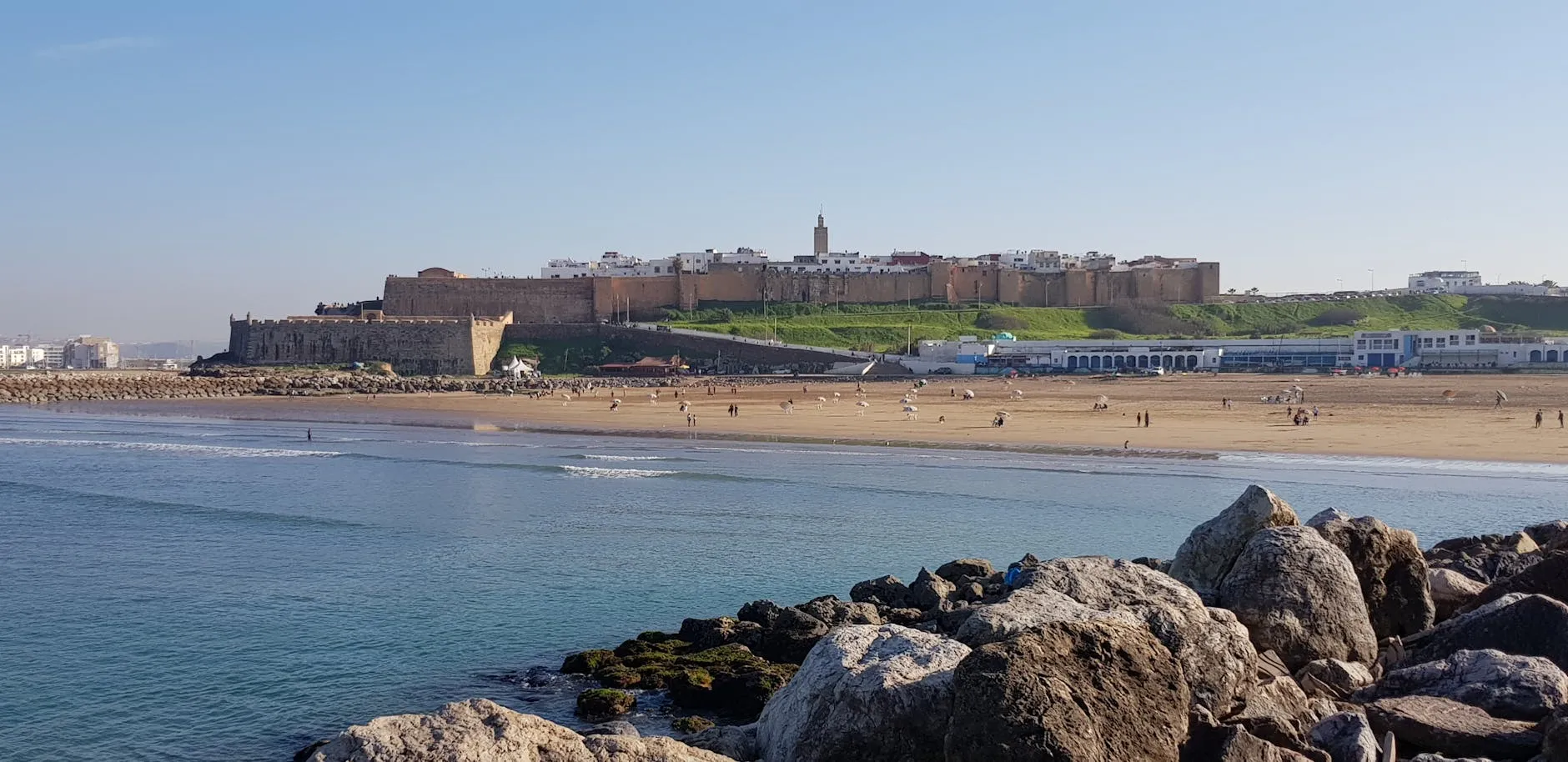 Scenic view of Rabat beach, fortress, and Atlantic Ocean waves.
