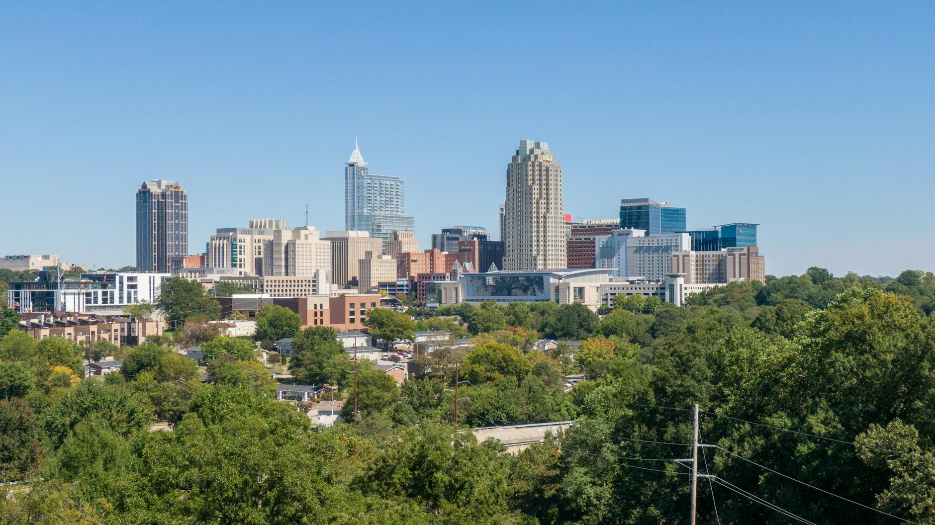 Raleigh-Durham International Airport (RDU) — A clear view of Raleigh's skyline, showcasing modern skyscrapers and urban greenery.
