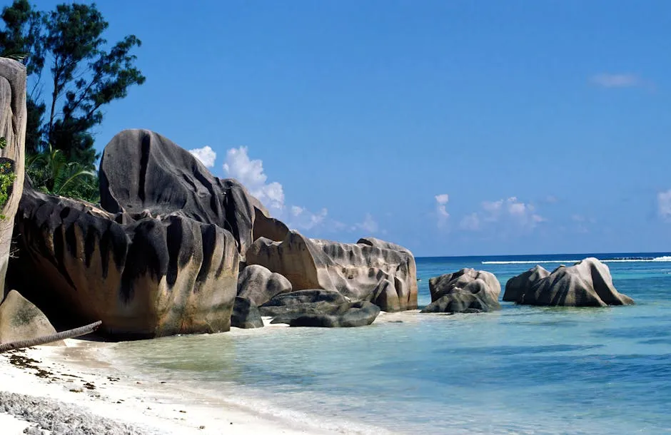 Stunning view of granite boulders on a beach in La Digue, Seychelles, under clear blue skies.