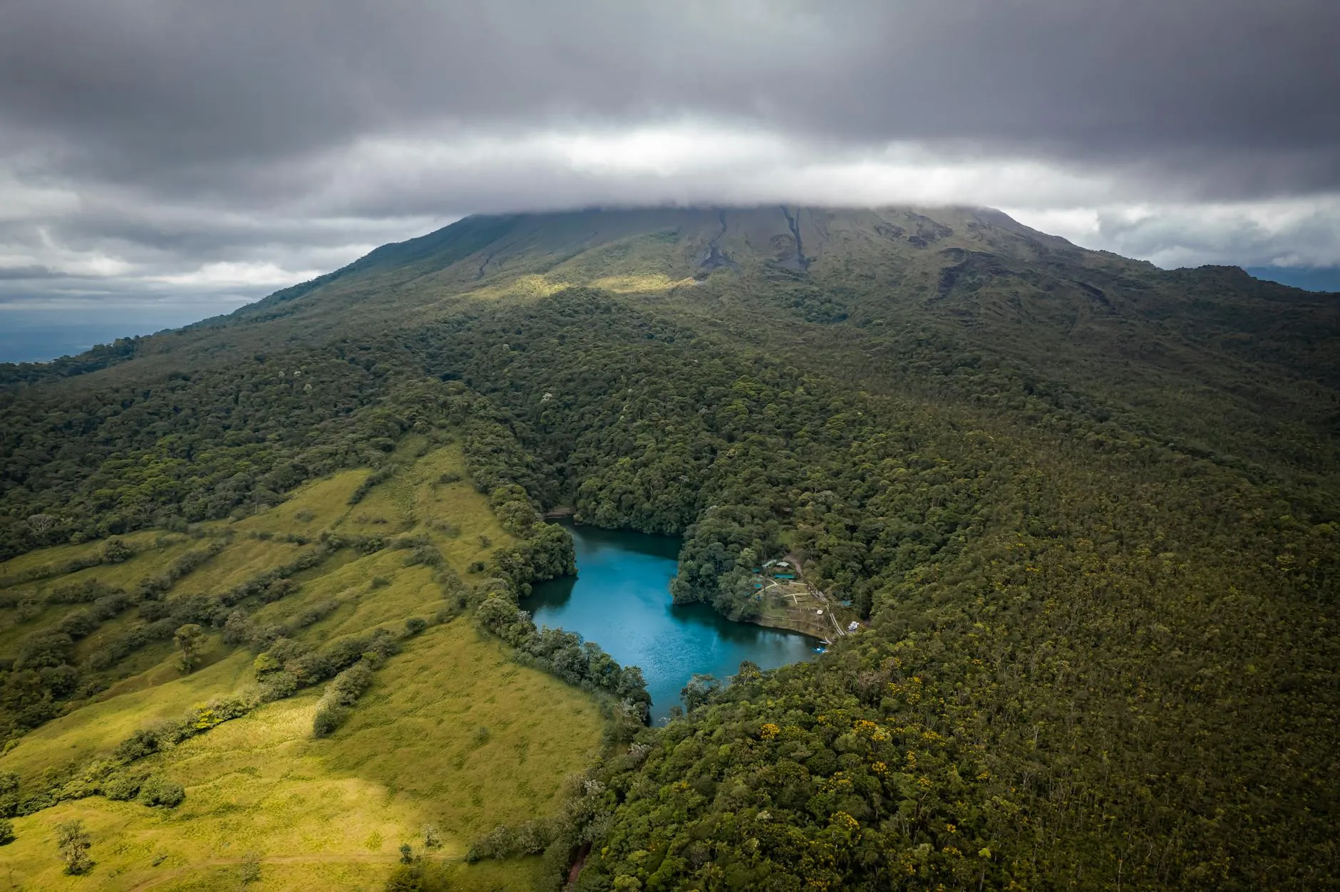 Costa Rica — Breathtaking aerial shot of greenery and lake near Arenal Volcano in Costa Rica under cloudy skies.
