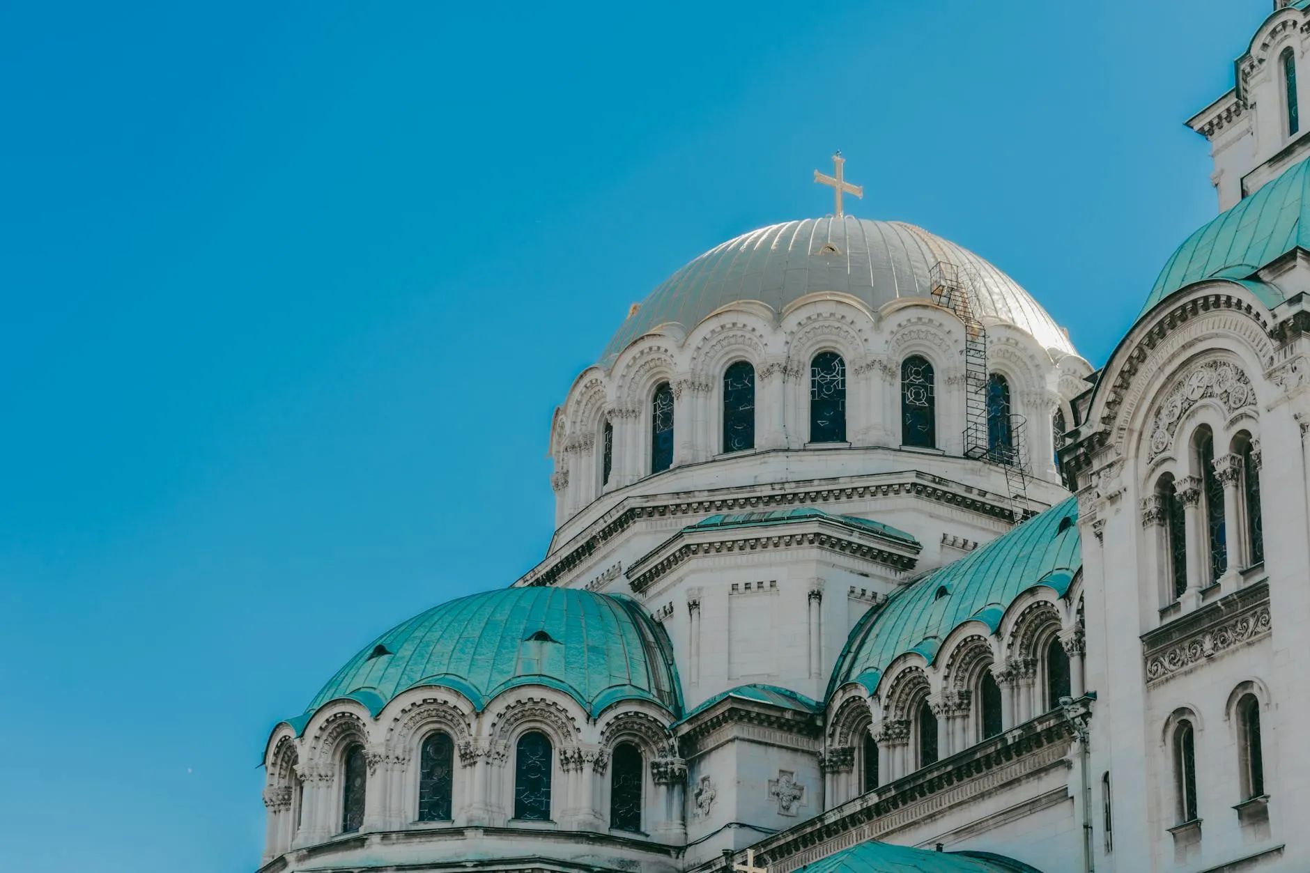The iconic domes of Alexander Nevsky Cathedral against a clear blue sky in Sofia, Bulgaria.