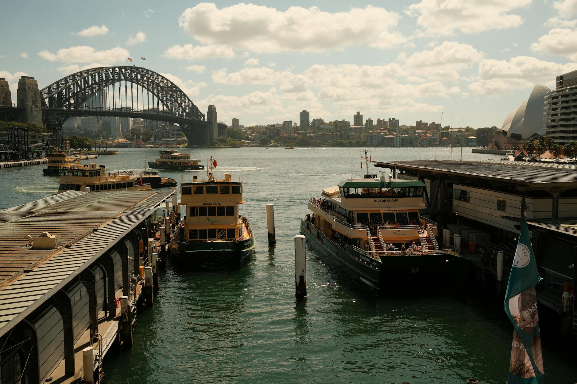 Scenic view of Sydney Harbour Bridge and Opera House with ferries docked at Circular Quay.