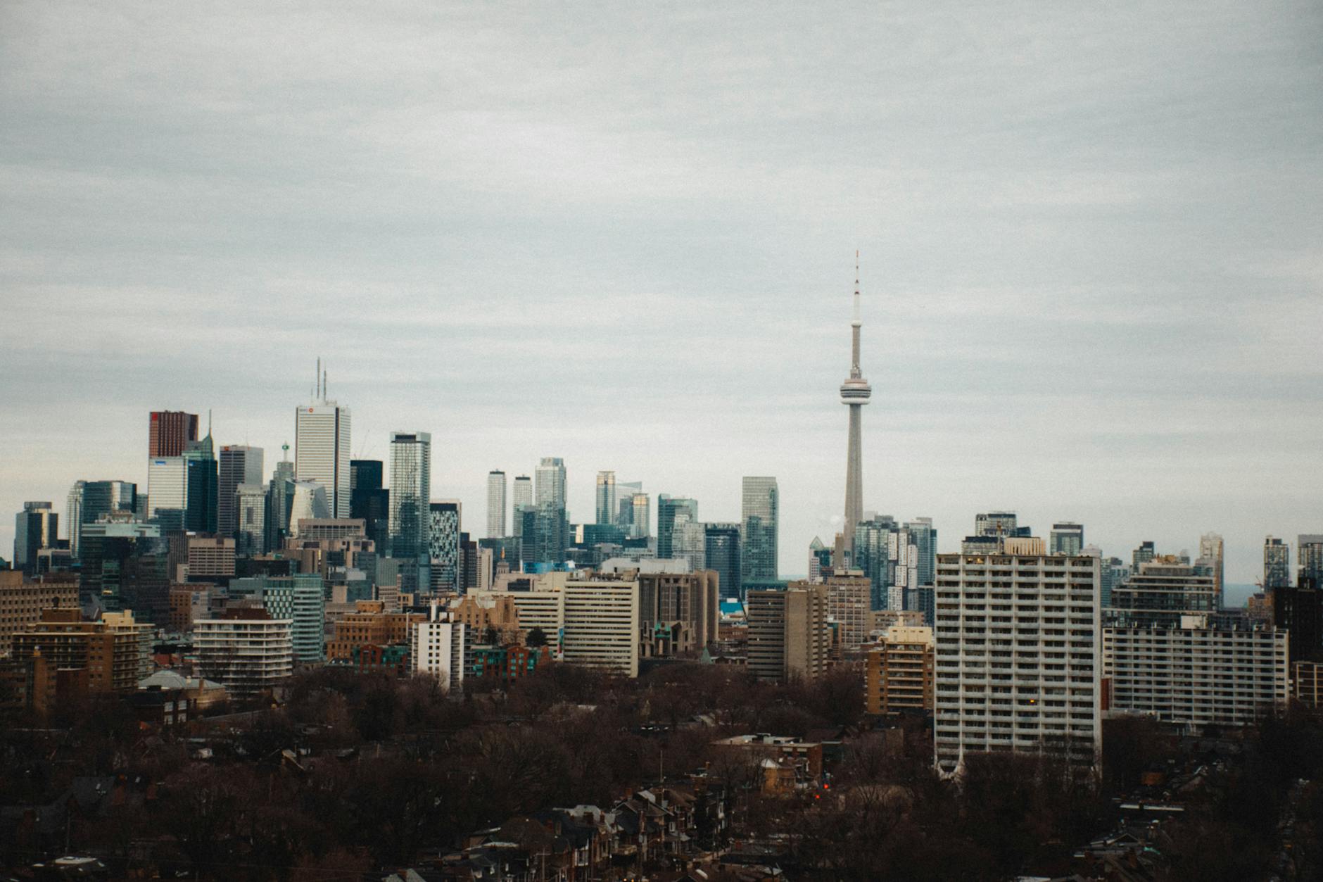 Stunning view of Toronto's skyline with the iconic CN Tower under a cloudy sky.