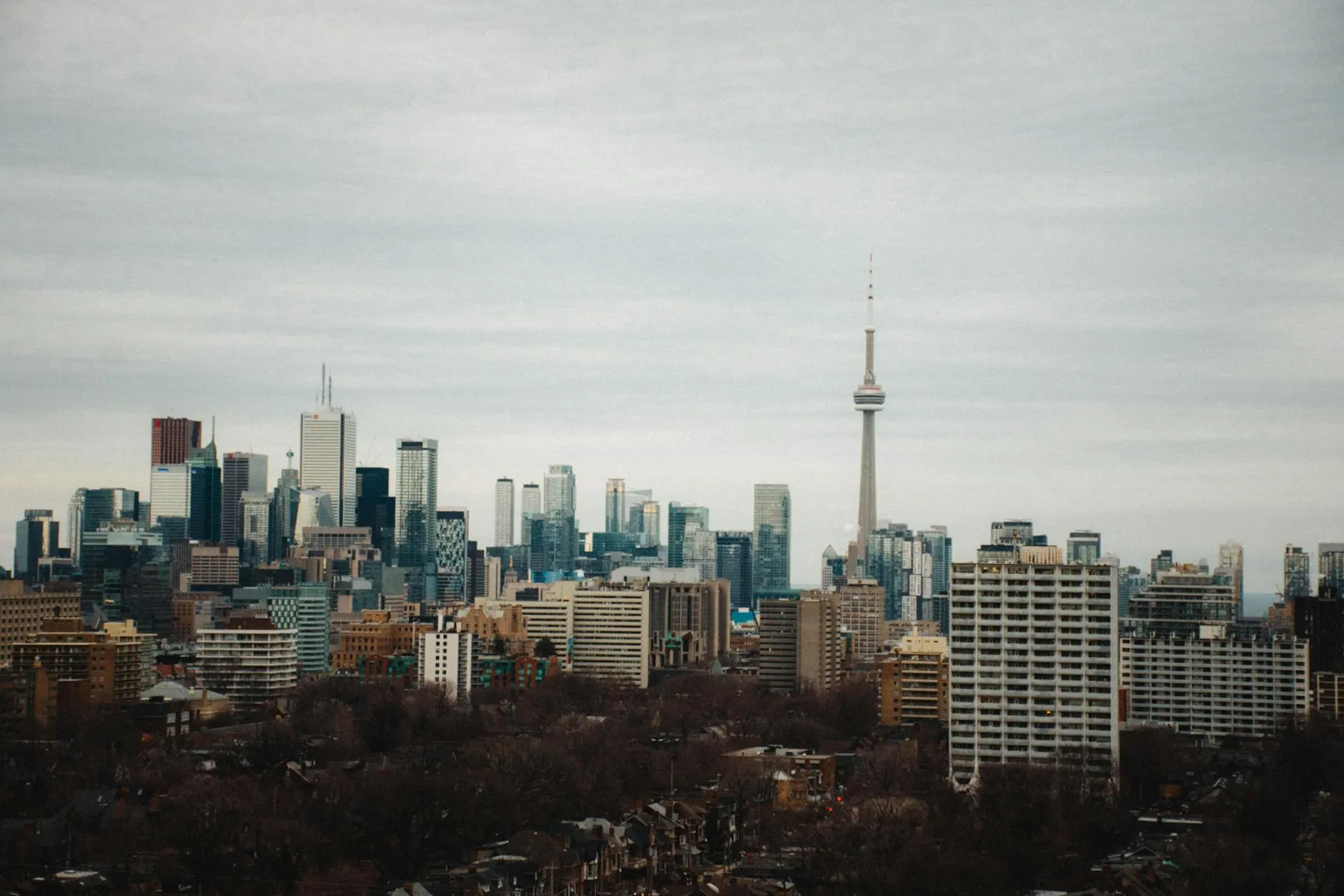 Stunning view of Toronto's skyline with the iconic CN Tower under a cloudy sky.