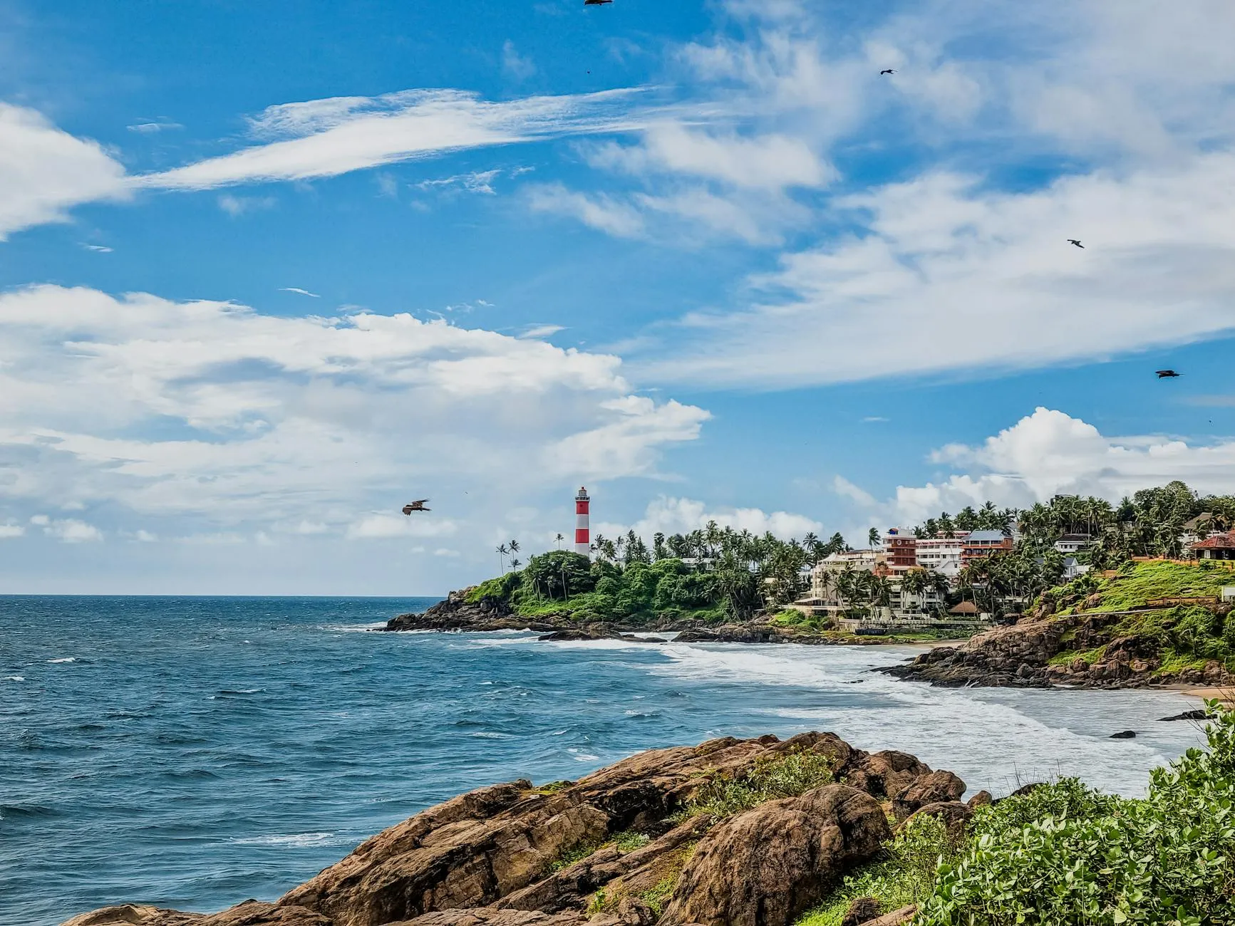 Thiruvananthapuram, India — Vibrant coastal landscape featuring Kovalam Beach and lighthouse in Kerala, India.