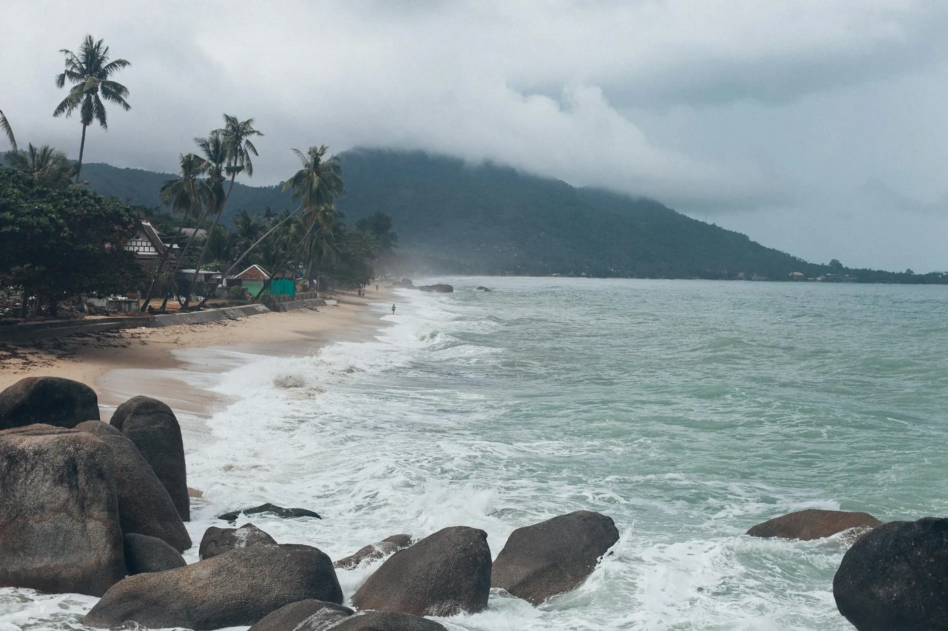 Koh Samui, Thailand — Serene view of a tropical beach in Koh Samui, Thailand, with crashing waves and lush greenery.