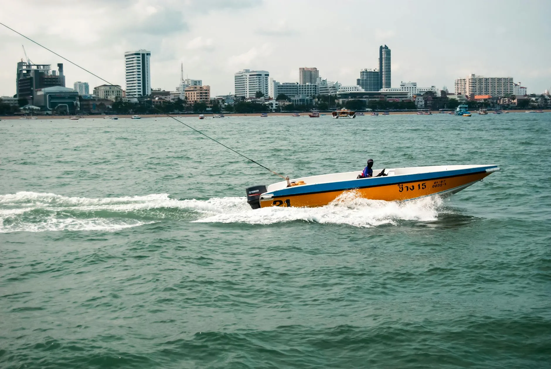 Pattaya, Thailand — Dynamic shot of a speedboat in Pattaya Bay, Thailand, with a vibrant cityscape backdrop.
