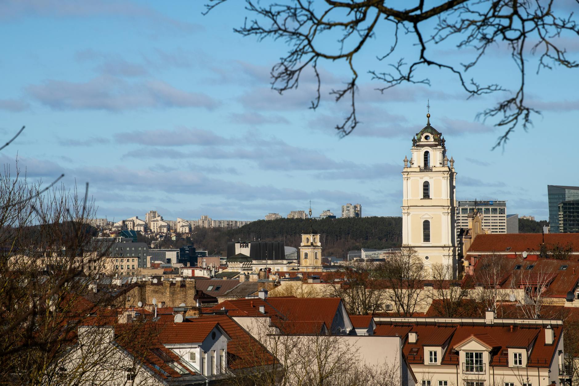 A beautiful view of Vilnius city featuring historic architecture and a prominent church tower under a clear sky.