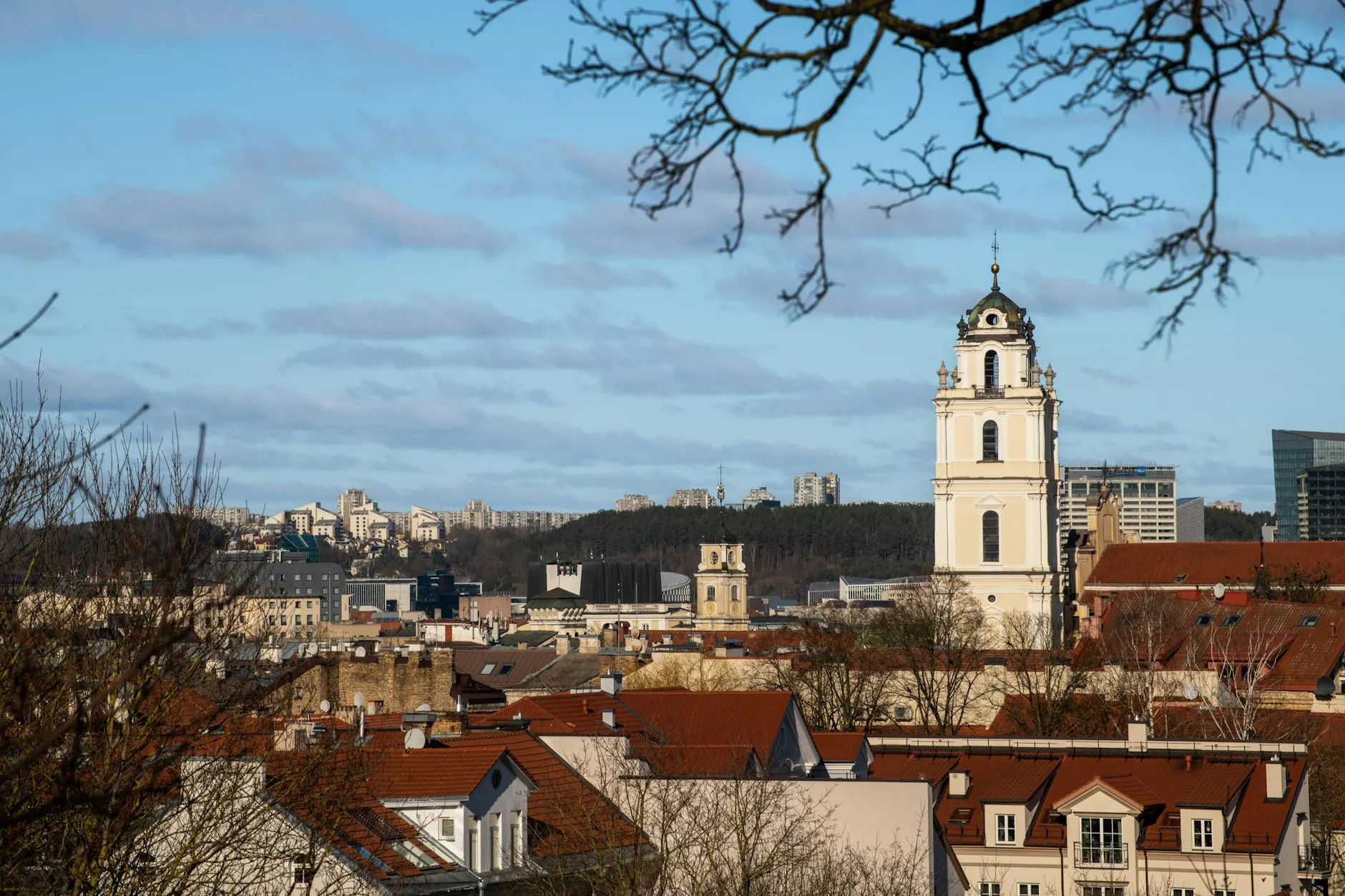 A beautiful view of Vilnius city featuring historic architecture and a prominent church tower under a clear sky.